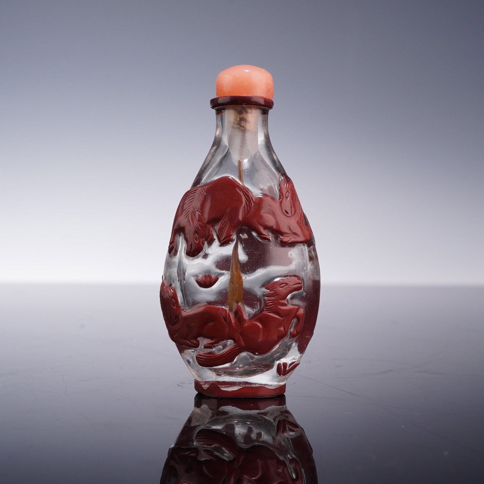 Chinese Red Overlay Peking Glass Snuff Bottle with Stopper: This Chinese Peking glass snuff bottle is crafted in a red-on-clear overlay technique. The vessel is constructed with a clear glass body featuring a translucent snowflake or frosted ground, adorned wi