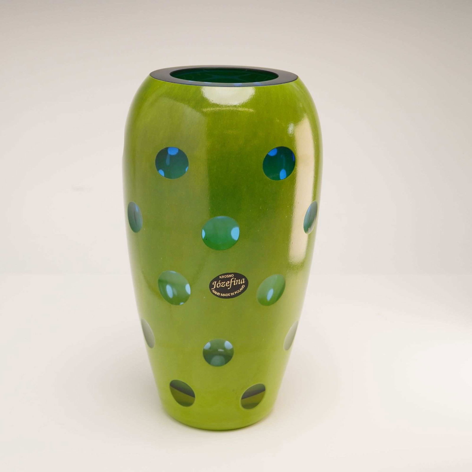 Jozefina Glassworks Krosno Poland Art Glass Lens Cut Vase: This mid-century modern style art glass vase is a product of the Jozefina Glassworks in Krosno, Poland. The vessel features a tapered ovoid form constructed from cased glass, with a vibrant lime green