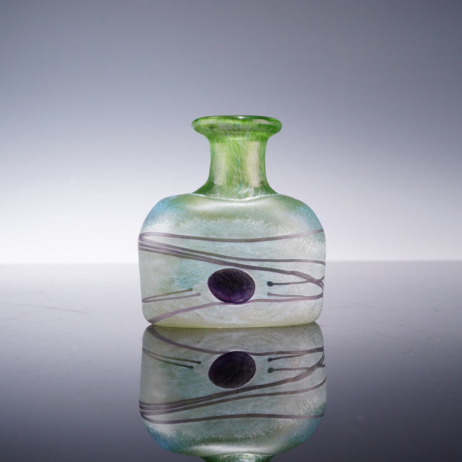 Bertil Vallien for Kosta Boda Miniature Galaxy Art Glass Bud Vase: This hand-blown glass bud vase is from the Galaxy series designed by Bertil Vallien for the Boda Artist Collection. The vessel features a flattened ovoid body with a frosted or acid-etched exterior su