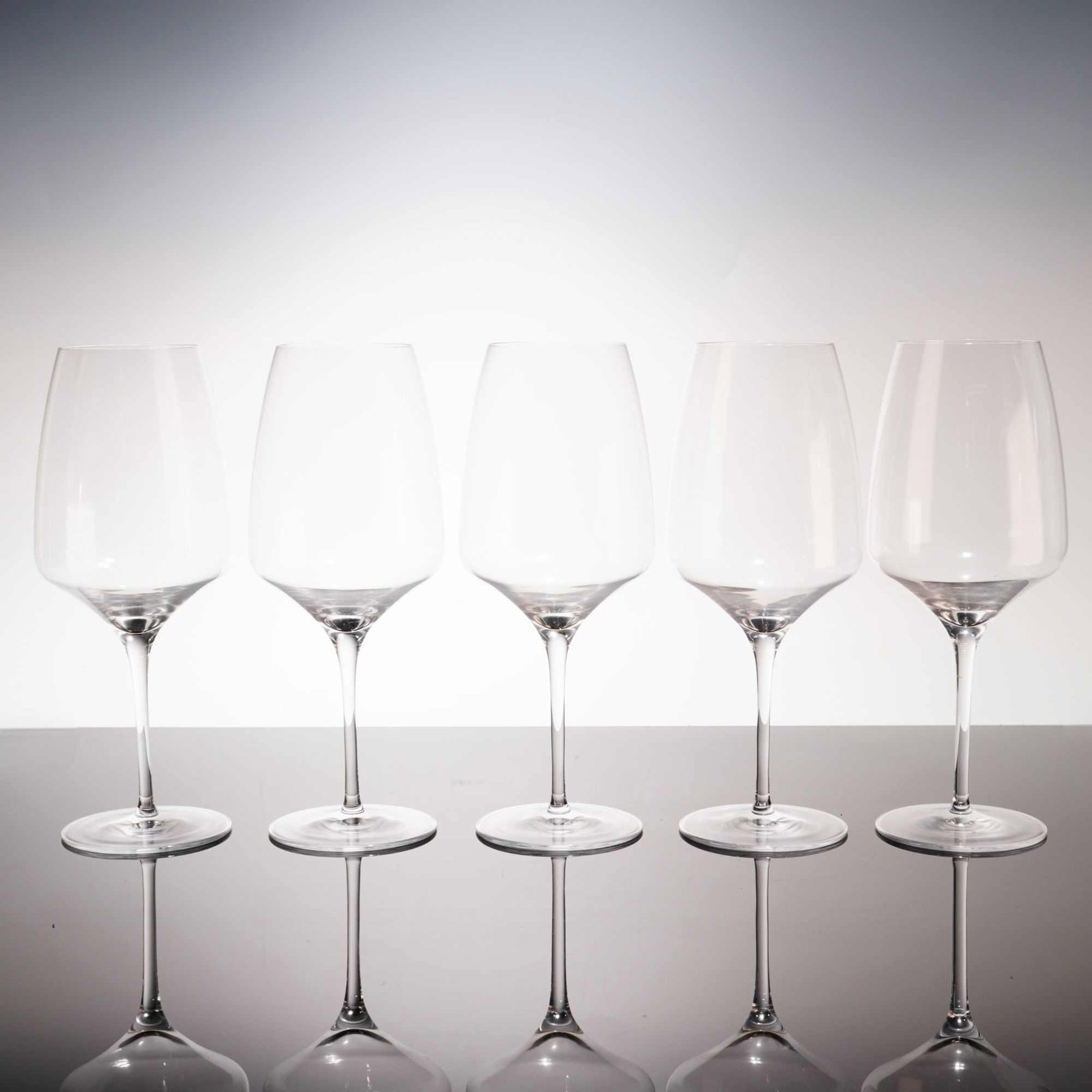 Set of Five Stolzle Lausitz German Crystal Red Wine Glasses: A set of five contemporary red wine glasses produced by the German manufacturer Stolzle Lausitz. Each glass is crafted from clear, lead-free crystal. The design consists of a broad, slightly angular b