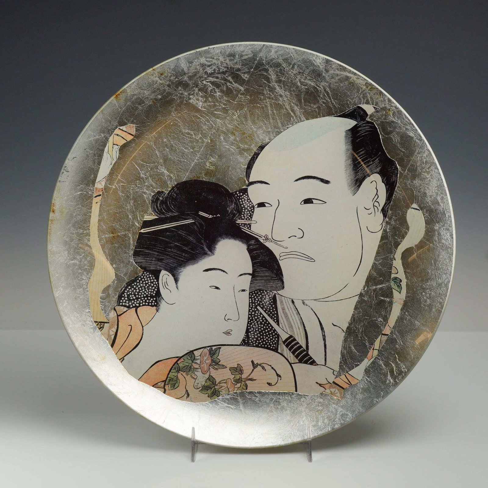 Carole Stupell Mid-Century Japanese Motif Plate with Gold Leaf Finish: A mid-century modern decorative plate featuring a Japanese motif, signed by Carole Stupell on the reverse. The central image depicts a man and woman in traditional Edo-period dress in the ukiyo-e styl