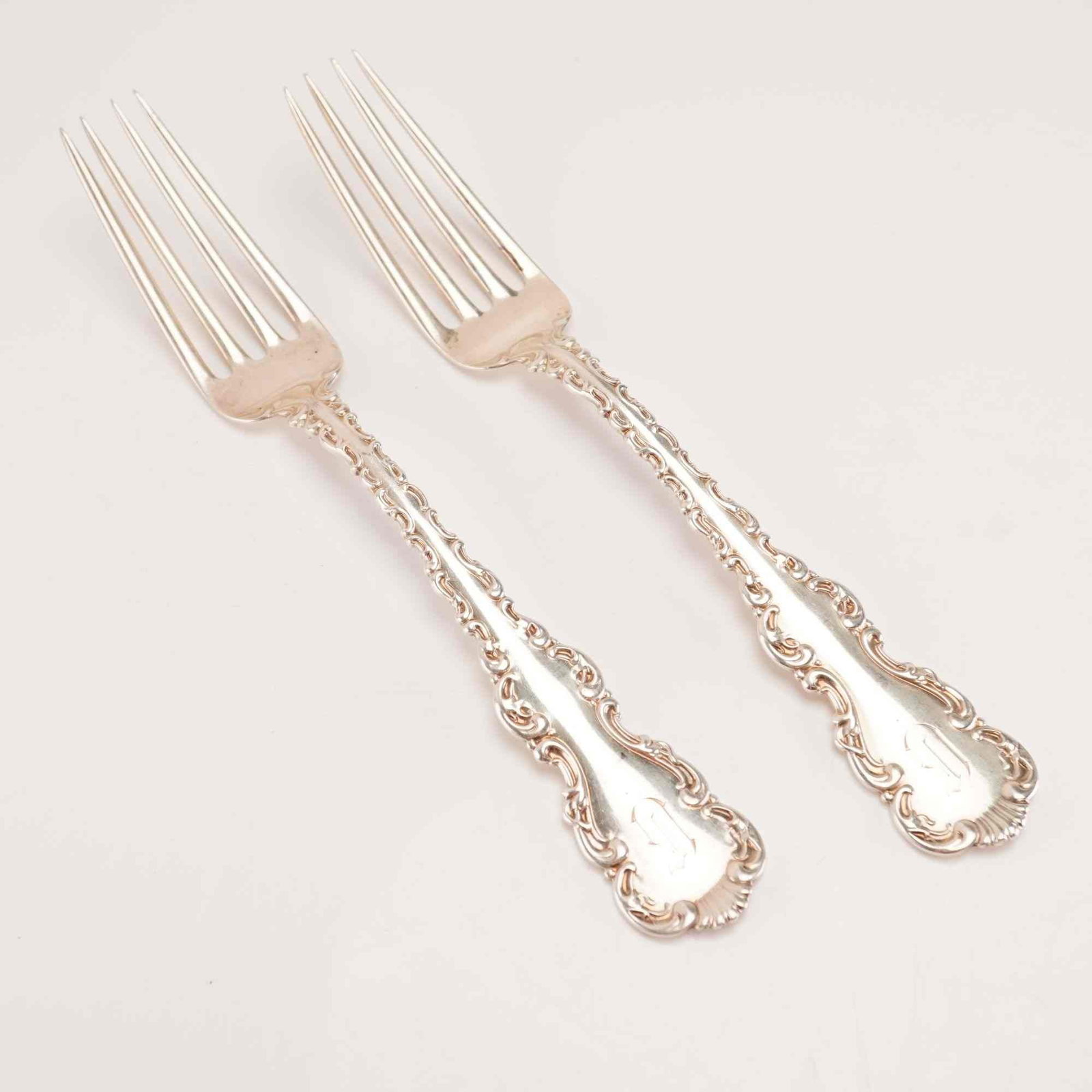 2pc Whiting Manufacturing Company Sterling Silver Place Forks, Louis XV: A pair of solid sterling silver place forks in the Louis XV pattern by the Whiting Manufacturing Company. Introduced in 1891, the pattern features Rococo Revival styling with ornate scrolling handle e