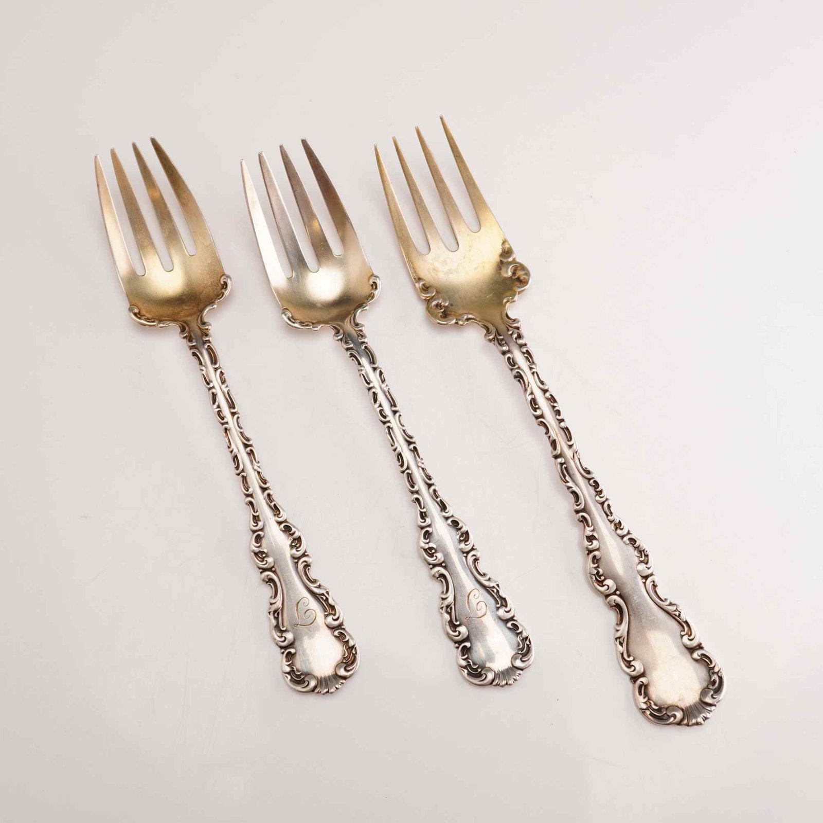 3pc Whiting Manufacturing Company Sterling Silver Ice Cream Forks, Louis XV: A trio of sterling silver ice cream forks in the Louis XV pattern by the Whiting Manufacturing Company. Each fork features a wide, shallow, gold-washed bowl with four short, pointed tines. The handles