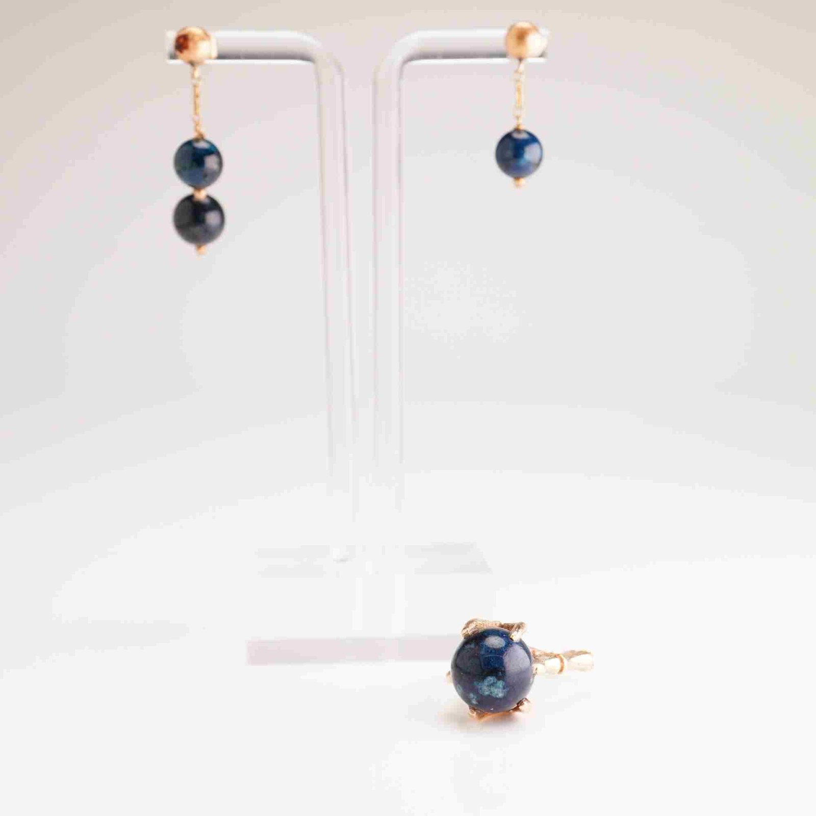 14K Yellow Gold Ring and Earrings Suite with Blue Gemstone Spheres: This jewelry suite consists of a ring and a coordinating pair of dangle earrings crafted in 14 karat yellow gold. The set features spherical gemstone beads of a dark blue color with lighter blue and