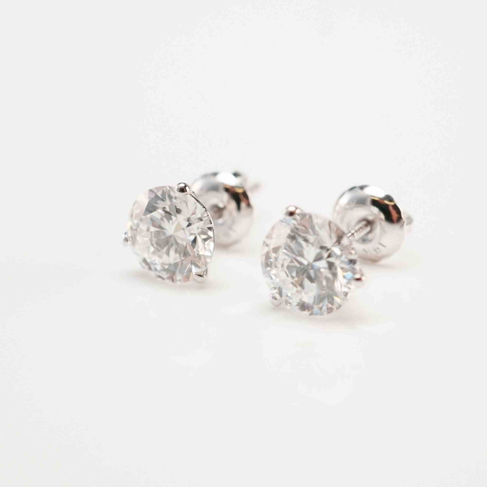 14K White Gold 2.10ctw Diamond Stud Earrings: A pair of white gold screw-back stud earrings set with round brilliant-cut lab-grown diamonds, each secured in a martini-prong setting. The diamonds are D color, VS1 clarity, with a total combined