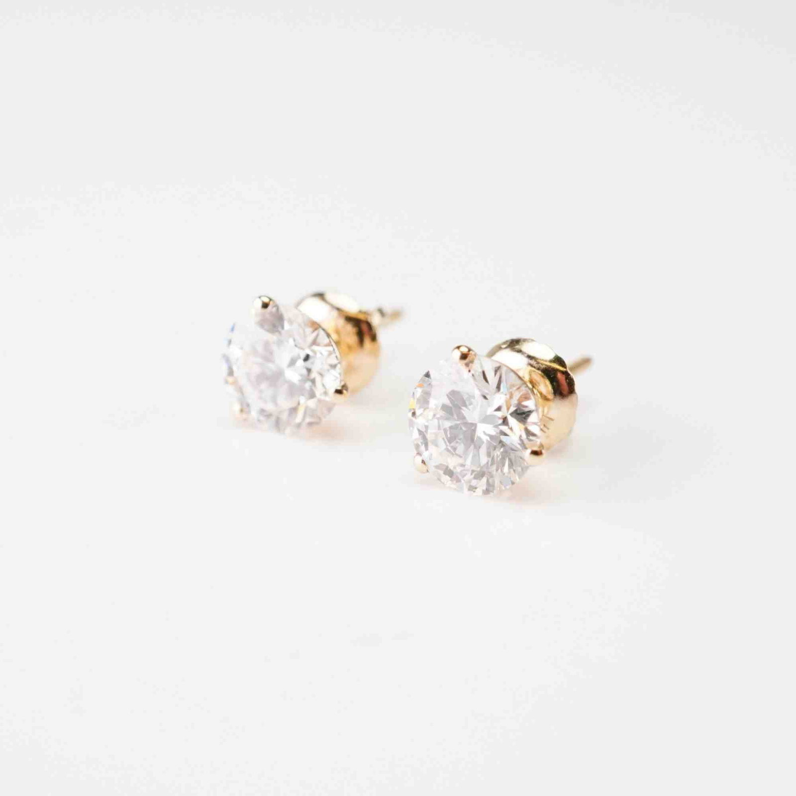 14K Gold 1.86ctw Diamond Stud Earrings: Crafted in yellow gold, this pair of stud earrings features round lab-grown diamonds, each set in a martini-prong setting and secured with screw-back closures. The diamonds are E color, VS1 clarity,