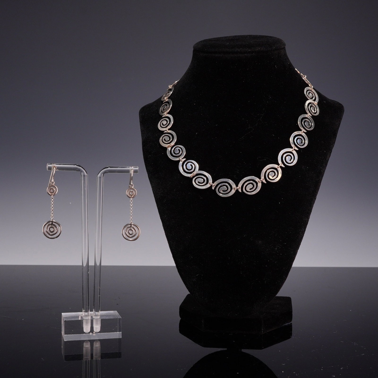 3pc Sterling Silver Greek Spiral Necklace and Earrings: This 3pc sterling silver jewelry suite consists of a matching necklace and a pair of drop earrings featuring an openwork Greek spiral motif. The collar-style necklace is composed of approximately twen