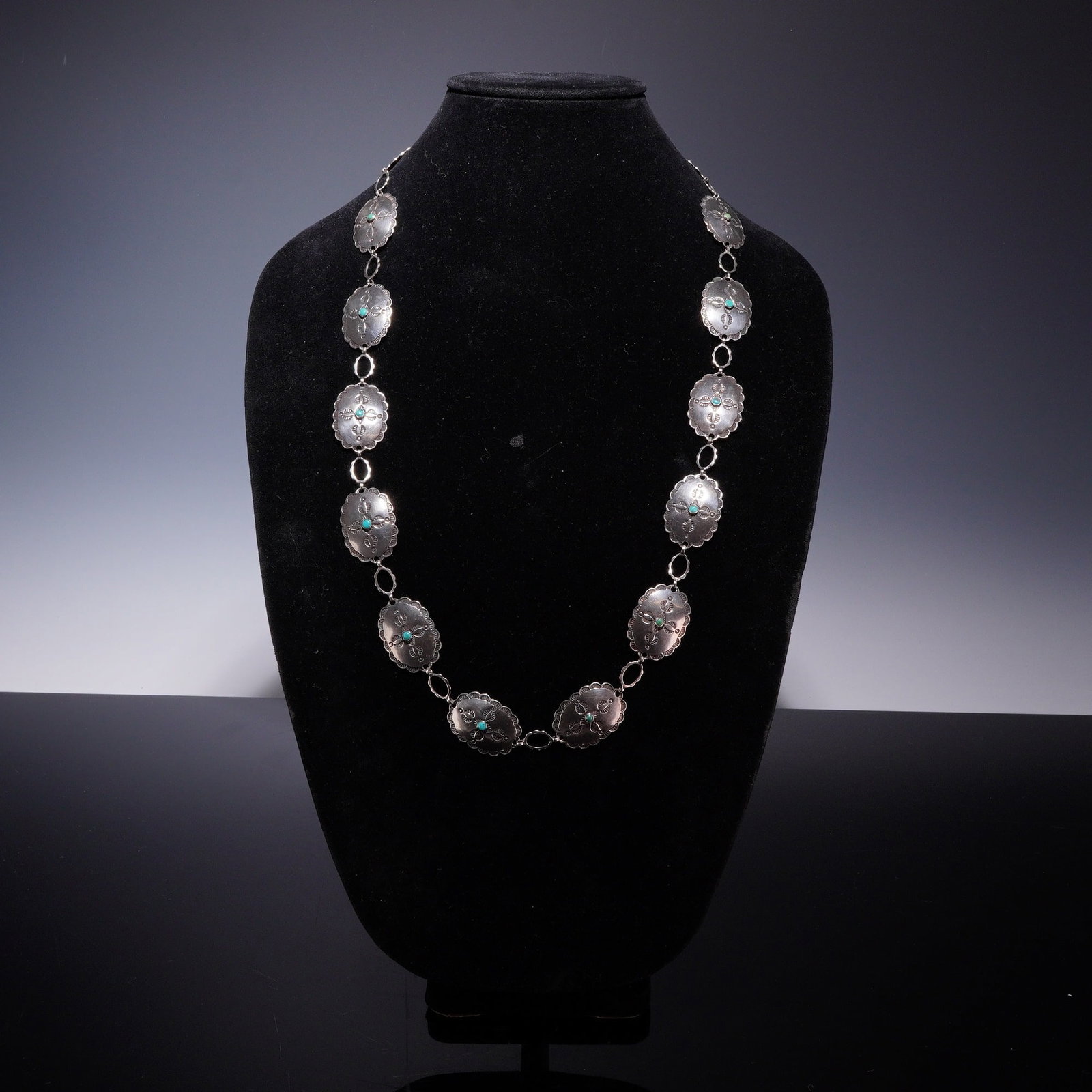 Sterling Silver Southwestern Style Concho Necklace with Turquoise: This Southwestern style concho necklace is crafted from sterling silver, as confirmed by testing. The belt features ten oval conchos, each accented with a central round turquoise cabochon set in a