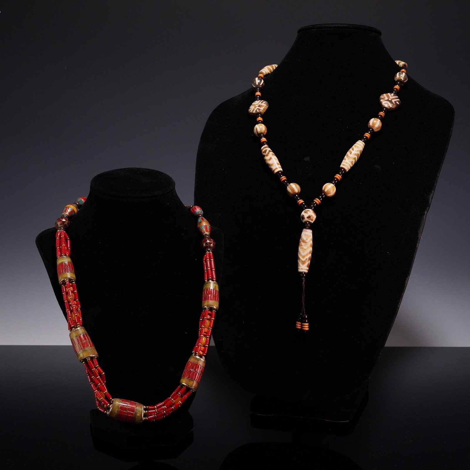 2pc Southwestern Style Costume Jewelry Necklaces: This lot consists of two beaded necklaces in various ethnic styles. The first is a multi-strand necklace featuring three rows of red cylindrical beads. The design is accented with four large