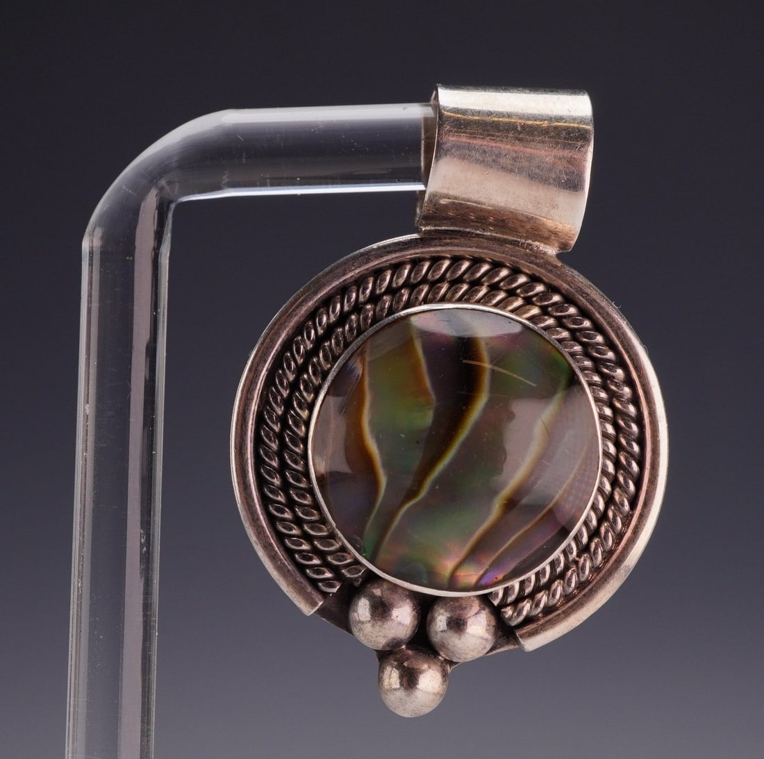 Sterling Silver 925 Abalone Shell Pendant: Vintage sterling silver 925 pendant featuring a polished abalone shell cabochon with iridescent tones of green, brown, and purple. The pendant is accented by a detailed twisted rope border and bead