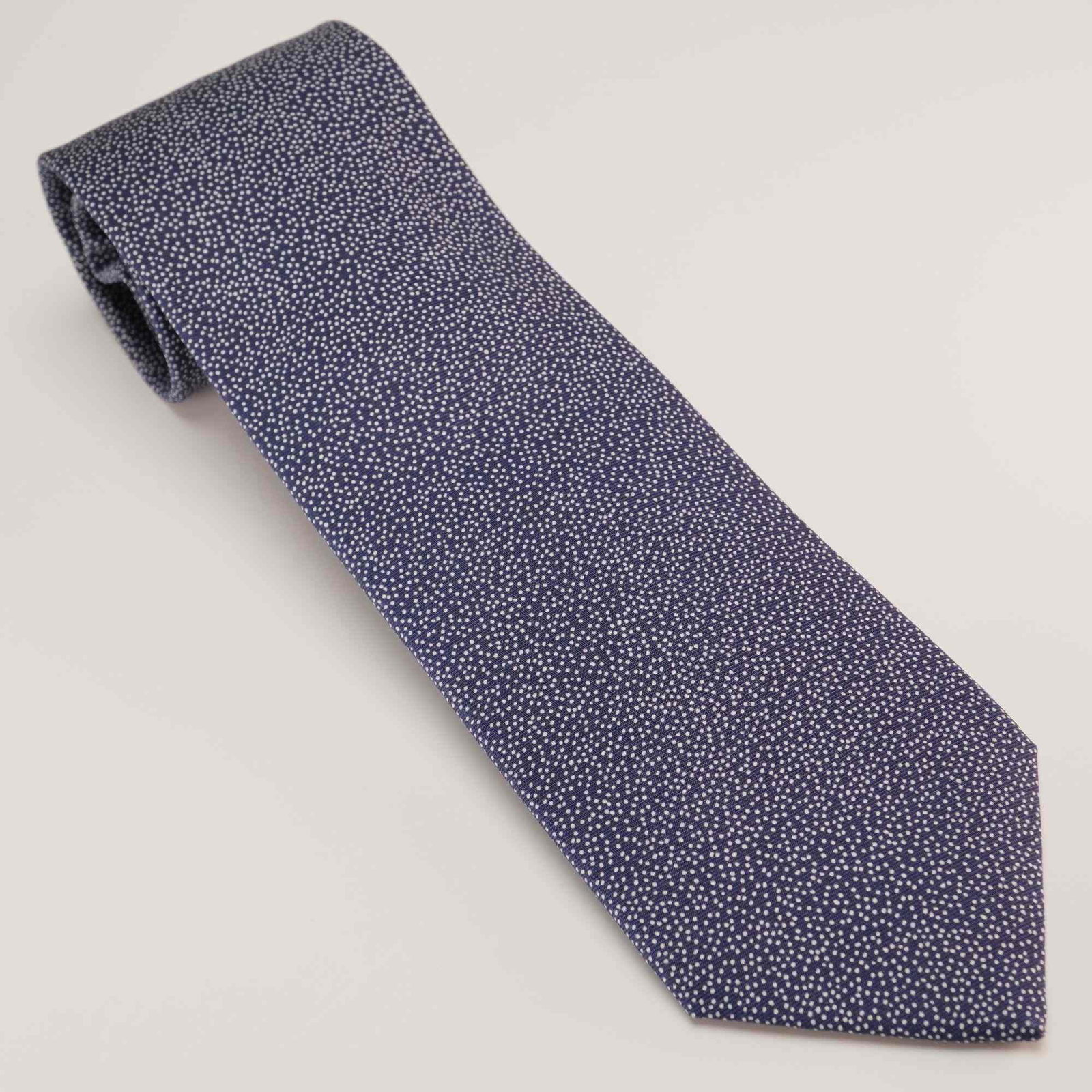 Hermes Paris 100% Silk Gentlemen's Tie in Navy Blue with White Dot Pattern: This Hermes 100% silk necktie features a dense, repeating micro-pattern of small white dots set against a navy blue ground. This gentlemen's accessory is constructed with high-quality silk and is made
