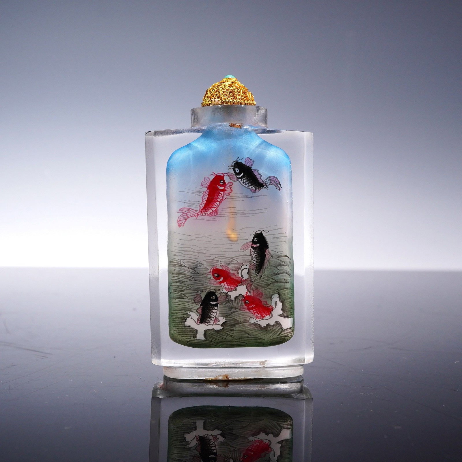 Chinese Reverse-Painted Glass Snuff Bottle with Carp and Stopper: A Chinese inside-painted (neihua) glass snuff bottle of rectangular form with rounded shoulders and a short neck. The interior is decorated with an aquatic scene featuring red and black carp. One face