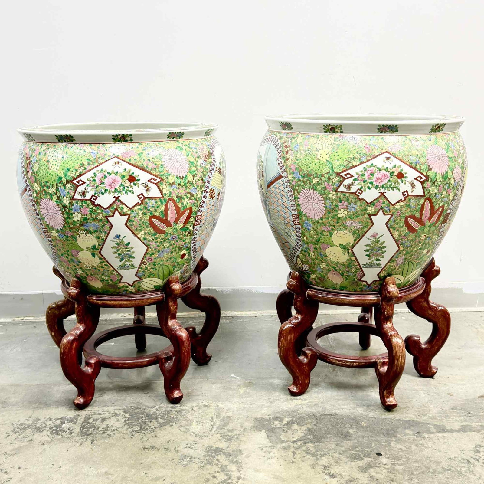 4pc Large Chinese Porcelain Fish Bowls with Carved Wood Stands: This lot consists of two large Chinese export porcelain fish bowls accompanied by two carved wood stands, for a total of four pieces. Each bowl is decorated in the Famille Rose palette with a dense mi