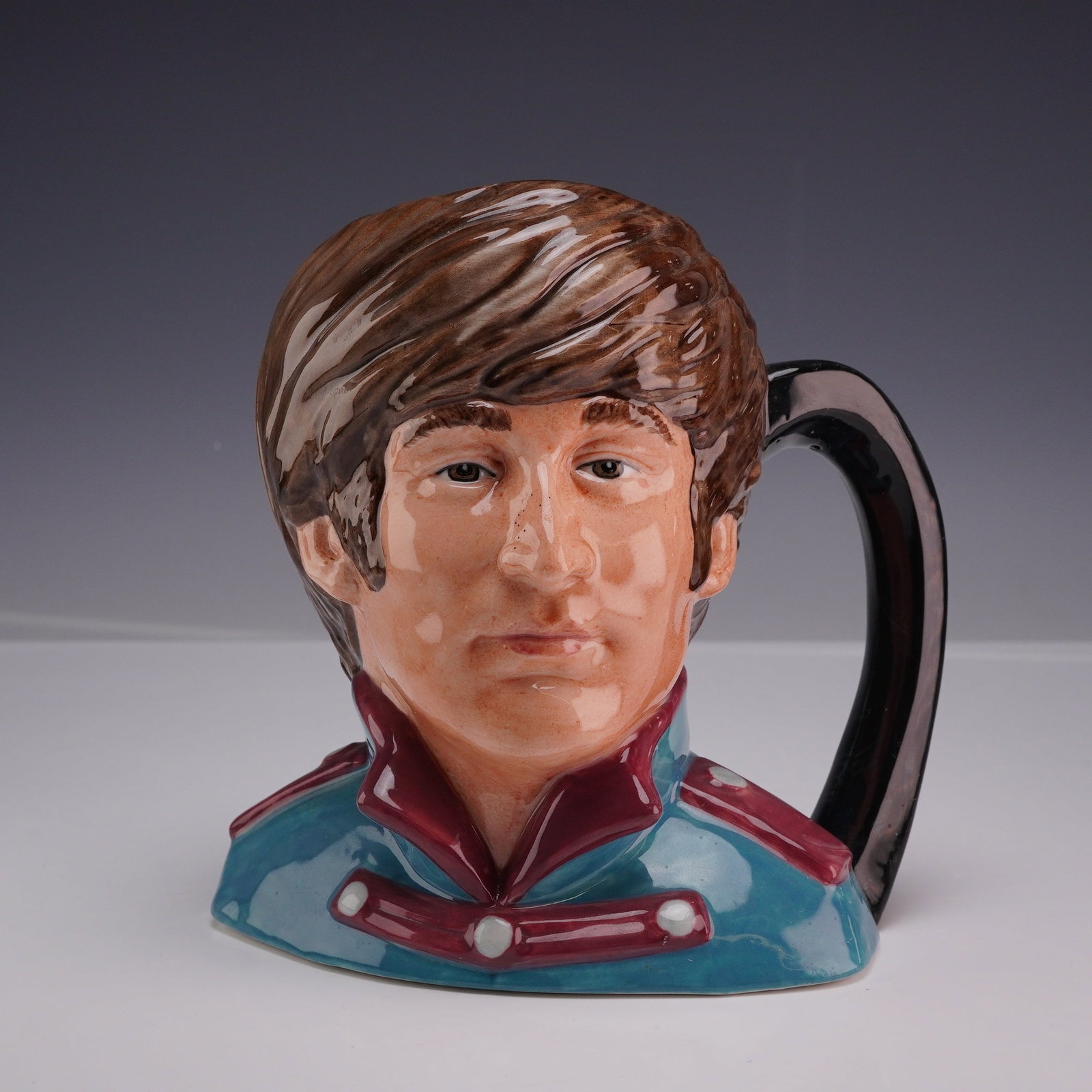 Royal Doulton John Lennon Character Jug D6725 The Beatles Series: This Royal Doulton earthenware character jug depicts John Lennon, modeled after his appearance during the Sgt. Pepper's Lonely Hearts Club Band era. The piece is part of The Beatles series and