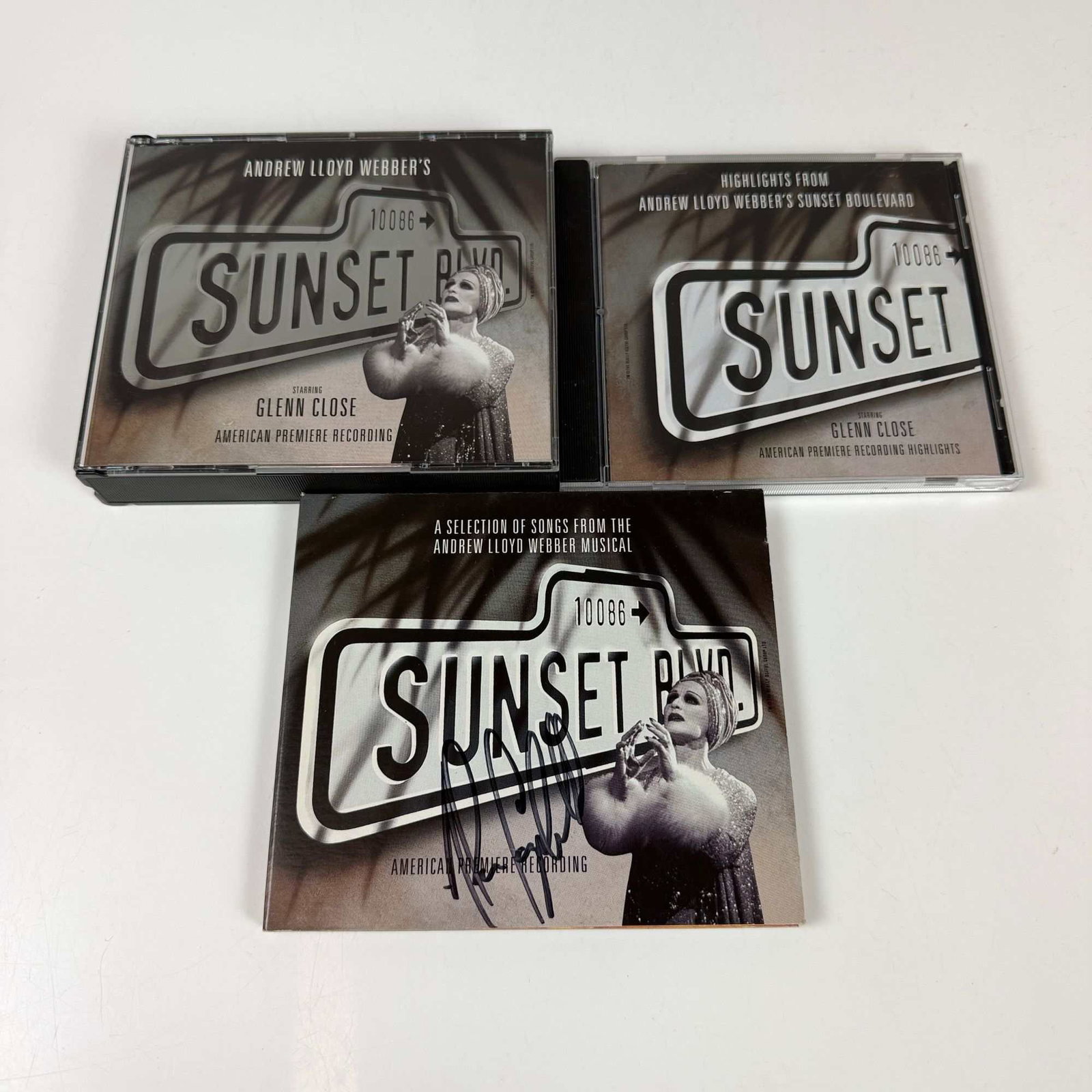 4pc Sunset Boulevard CDs, One Signed on Front Cover by Alan Campbell: A collection of four compact discs featuring recordings from the 1994 American Premiere of the Andrew Lloyd Webber musical Sunset Boulevard, starring Glenn Close. The collection includes the complete 
