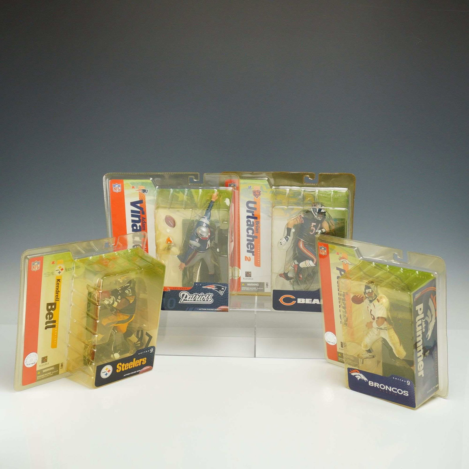 A 4pc Lot of McFarlane Toys NFL Series 9 Action Figures in Original Packaging: This collection consists of 4 McFarlane Toys NFL Series 9 action figures, each presented in its original retail blister pack. The lot features prominent players from the 2004 season, including linebac
