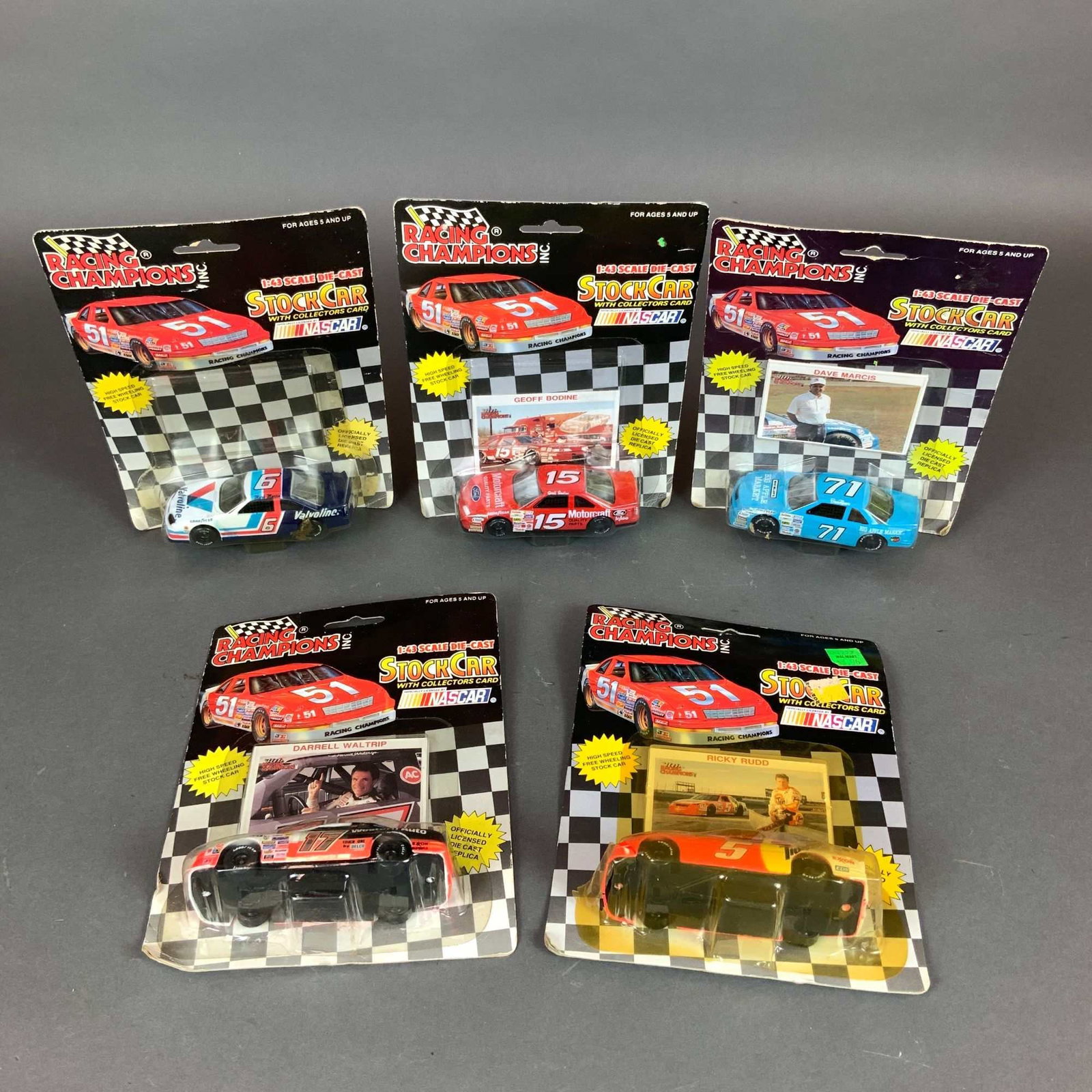 Five 1:43 Scale Racing Champions Inc. NASCAR Model Cars: A collection of five 1:43 scale die-cast NASCAR model cars produced by Racing Champions Inc. The group includes stock cars and corresponding collector cards for drivers Mark Martin (No. 6 Valvoline), 