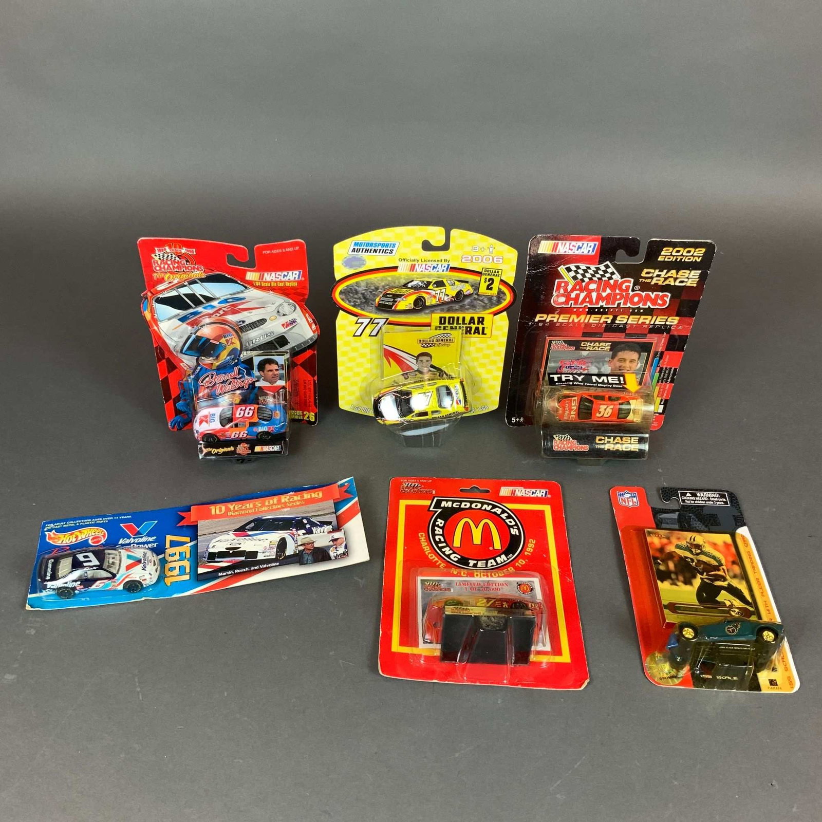 A Collection of 6 NASCAR Model Cars and Sports Die-Cast Collectibles: A collection of 6 NASCAR model cars and sports die-cast collectibles, primarily in 1:64 scale with one 1:55 scale set. This assortment includes a Racing Champions The Originals Darrell Waltrip #66 rep
