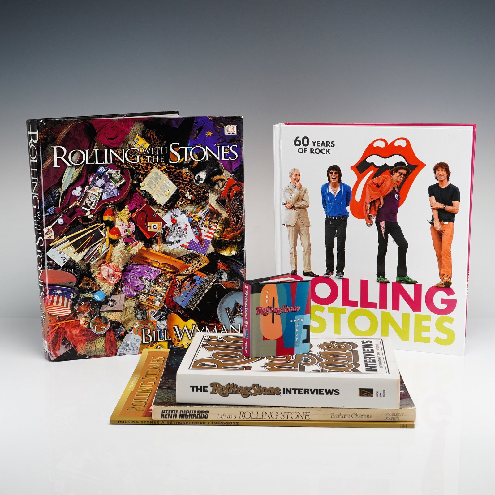 6pc Collection of Rolling Stones Hardcover and Softcover Books, Magazine and Pocket Book of Love: A 6pc collection of books and magazines focused on the rock band The Rolling Stones. The assortment includes several hardcover volumes and commemorative printed materials: Wyman, Bill. Rolling with
