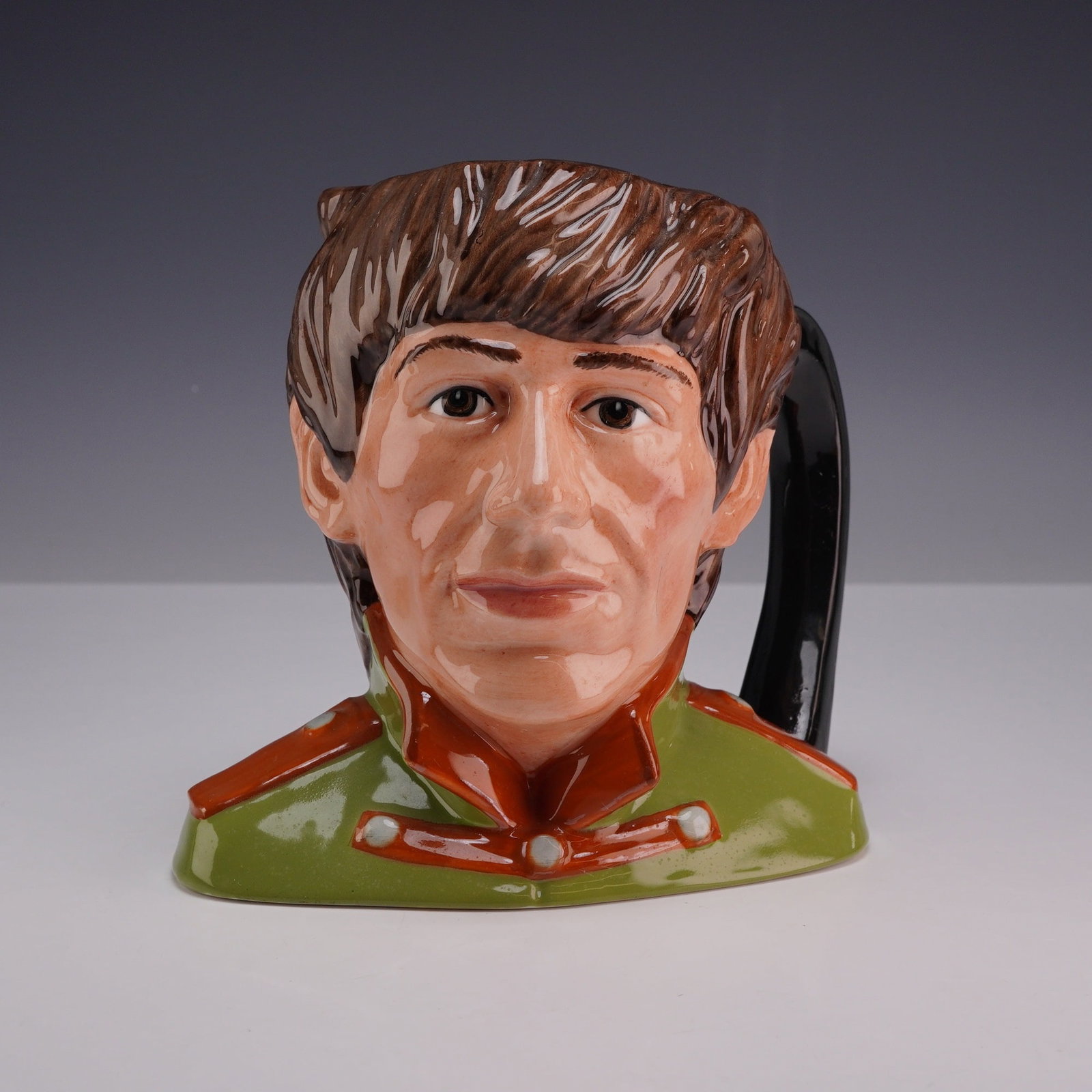 Royal Doulton The Beatles George Harrison Character Jug D6727: A Royal Doulton glazed earthenware character jug depicting George Harrison, produced as part of a series featuring members of The Beatles. This model, identified as D6727, features a modeled portrait 