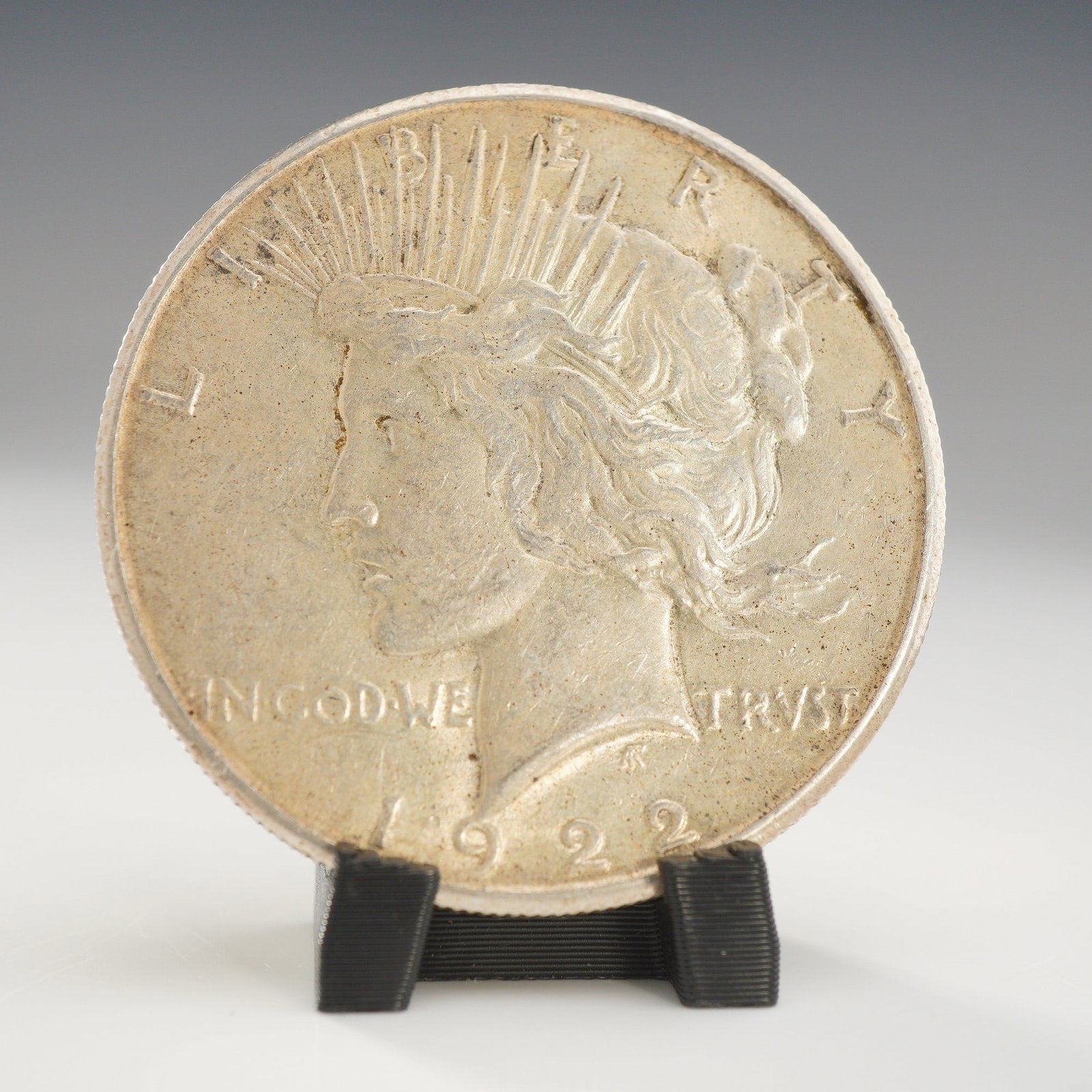 1922-S US Peace Silver One Dollar Coin, Circulated: This is a US 1922-S Peace silver dollar, struck at the San Francisco Mint. The coin is composed of 90% silver and 10% copper, corresponding to the KM# 150 catalog reference. The obverse displays the d