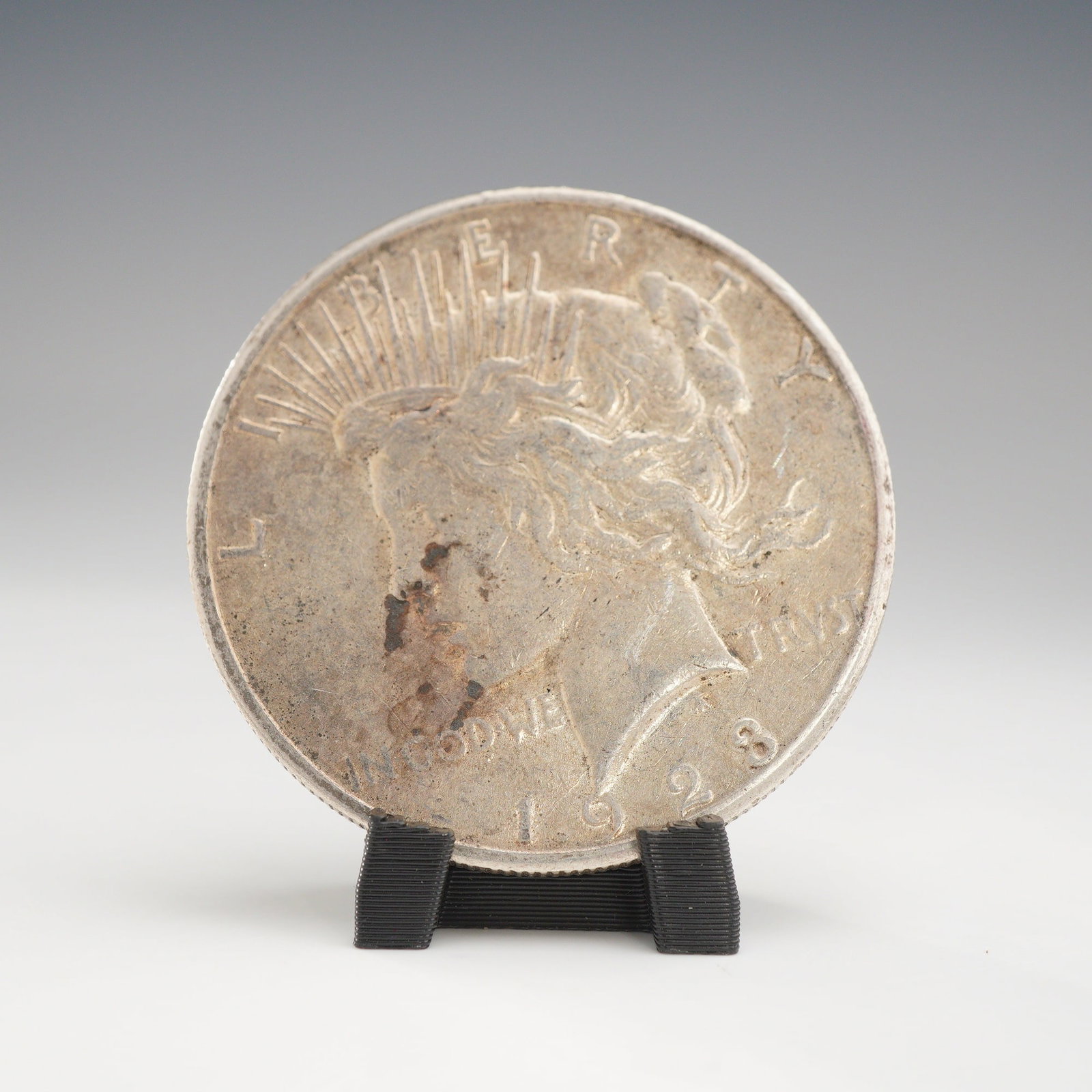 1923-S US One Dollar Peace Silver Dollar Coin, Circulated: A 1923 US 90% silver Peace silver dollar, produced by the San Francisco Mint. The coin features the standard Liberty obverse and eagle on rock reverse designs. The edge is reeded. The coin is designed