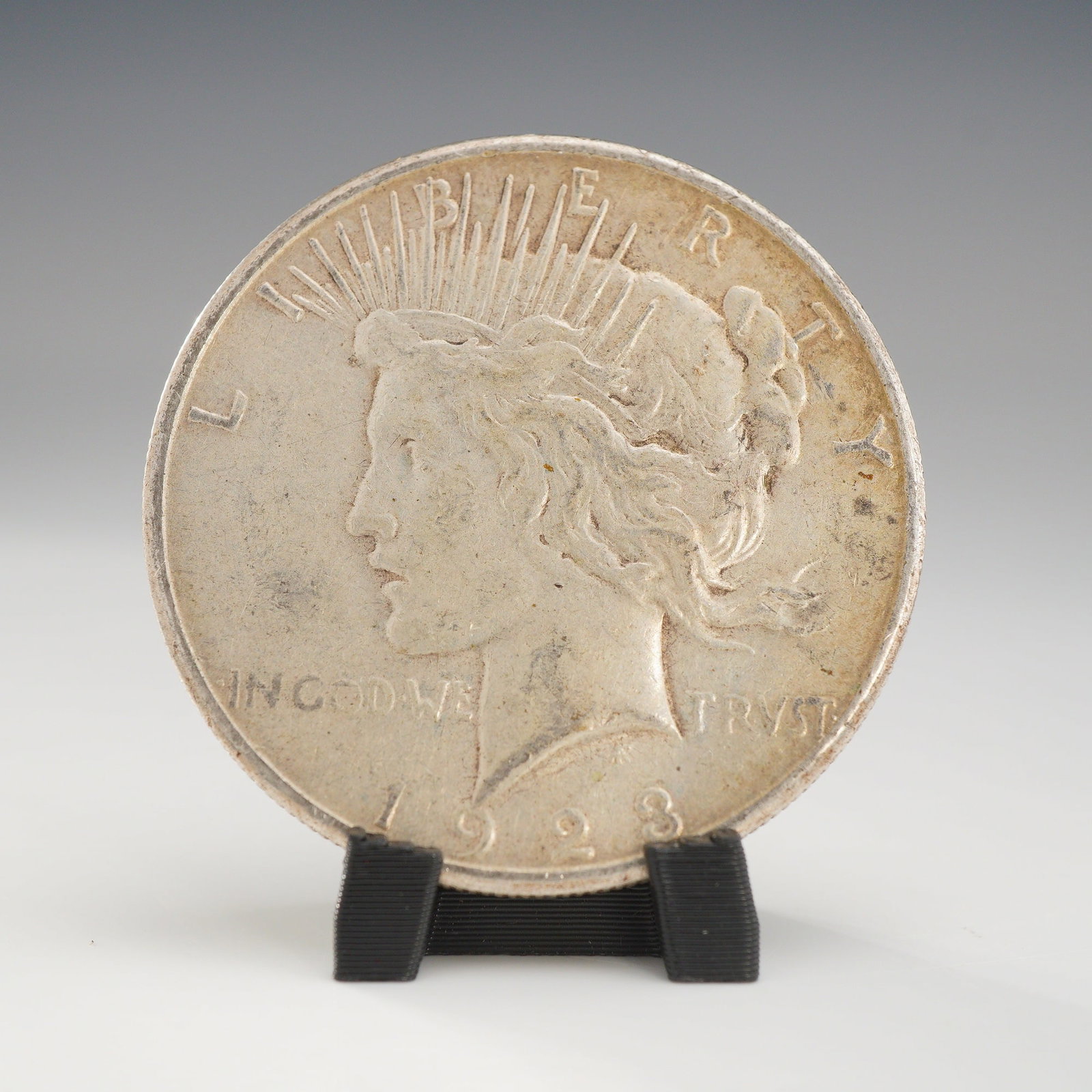 1923-S US Peace Silver One Dollar Coin, Circulated: This US 1923-S Peace silver dollar was struck at the San Francisco Mint and is composed of 90% silver. The coin features the standard Peace type obverse design with the inscriptions LIBERTY, IN GOD WE