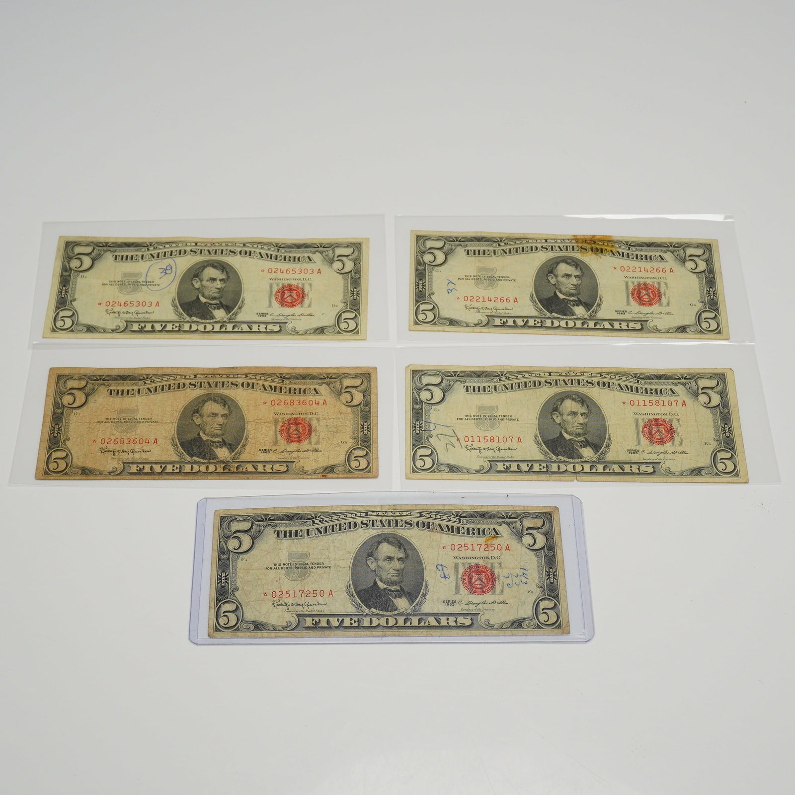 Five 1963 US Five Dollars Red Seal Star Notes: This collection of five US $5 United States Notes consists of Series 1963 red seal bills. Each banknote features the portrait of Abraham Lincoln on the obverse and the Lincoln Memorial on the