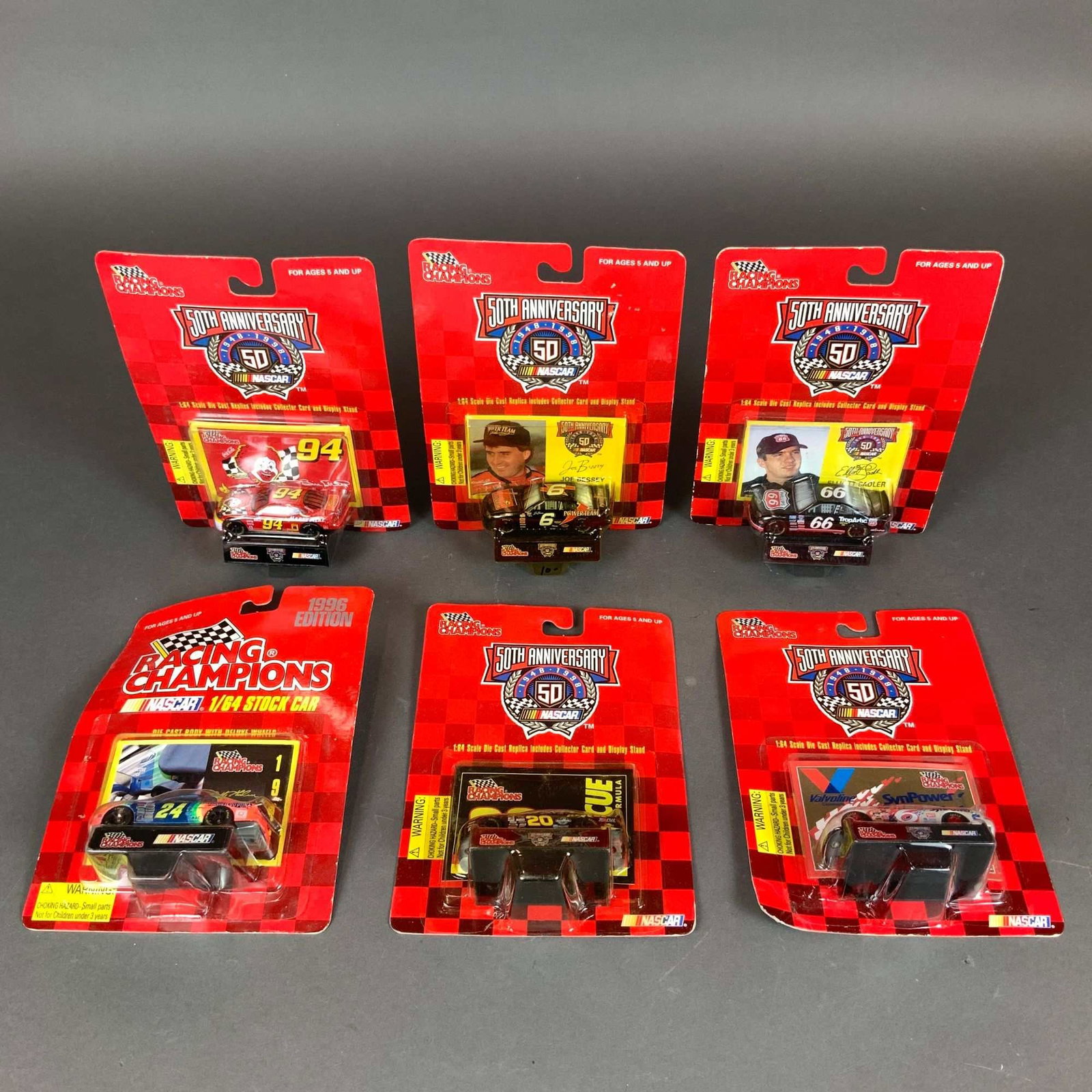 Six Racing Champions NASCAR 1/64 Scale Die-Cast Model Cars: A collection of six Racing Champions NASCAR die-cast model cars at 1/64 scale, preserved in their original blister pack packaging. The group features five vehicles from the 1998 NASCAR 50th Anniversar