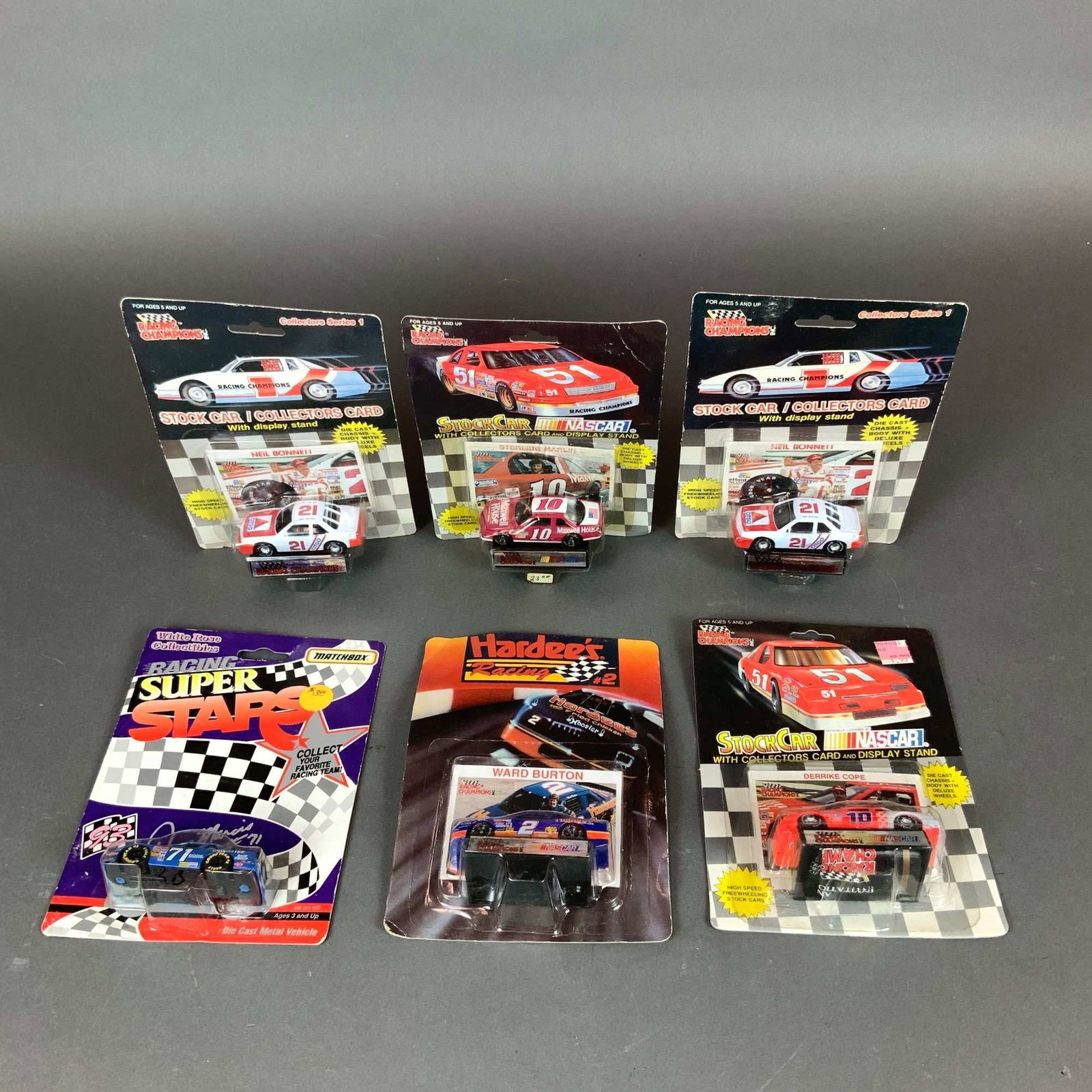 6pc NASCAR Collectible Die-Cast Stock Car Models including Racing Champions: A collection of six vintage 1:64 scale NASCAR die-cast stock cars in original factory blister packaging. This assortment includes items from the late 1980s and early 1990s manufactured by Racing Champ