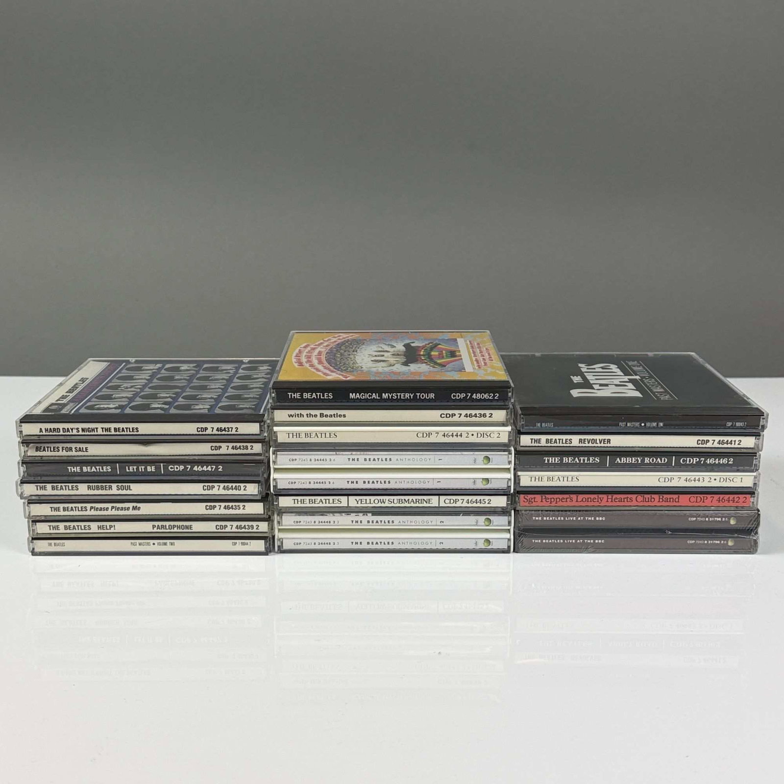 19pc Beatles CDs in Jewel Cases Including Unopened Titles: A collection of 19 compact discs by The Beatles, featuring the group's core studio album catalog and significant archival and compilation releases. The group primarily consists of the initial digital