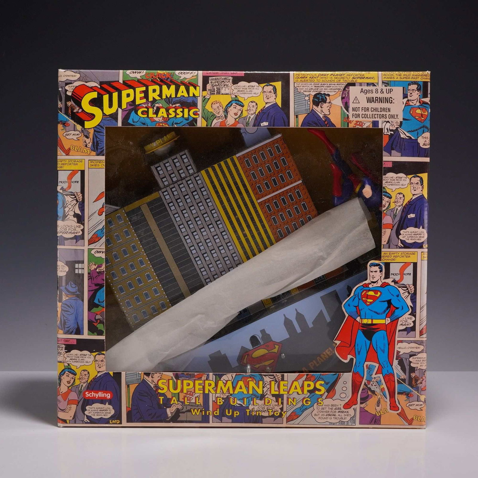 Schylling Superman Classic Leaps Tall Buildings Wind Up Tin Toy: This licensed Superman game in box is a wind-up tin lithograph toy manufactured by Schylling in 2003. The set consists of a lithographed tin building with a Superman figure designed to travel across