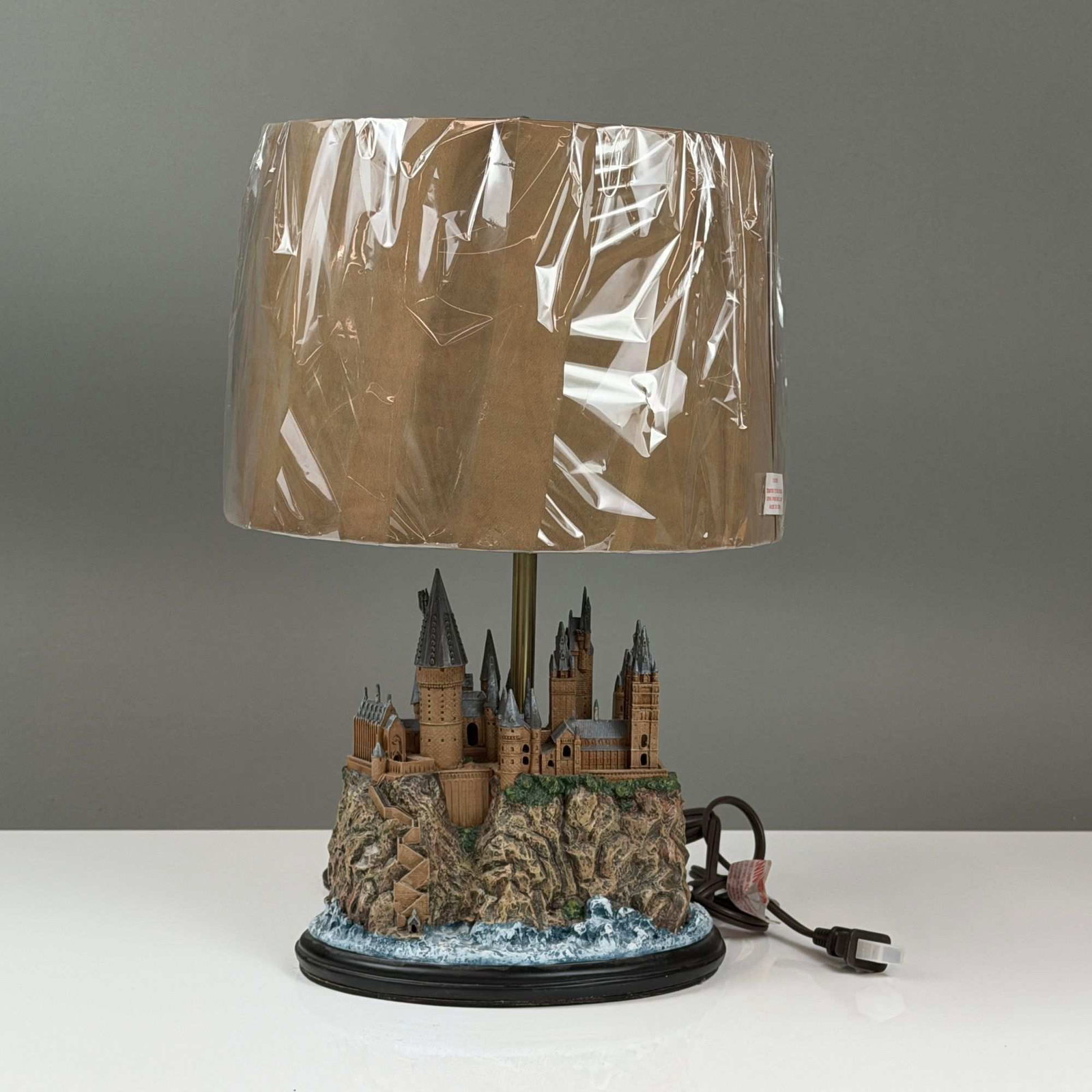 The Bradford Exchange Harry Potter Hogwarts Castle Table Lamp with Marauder's Map Shade: This novelty table lamp by The Bradford Exchange features a sculptural base depicting Hogwarts Castle from the Harry Potter film series. The base is constructed of hand-painted cast resin,