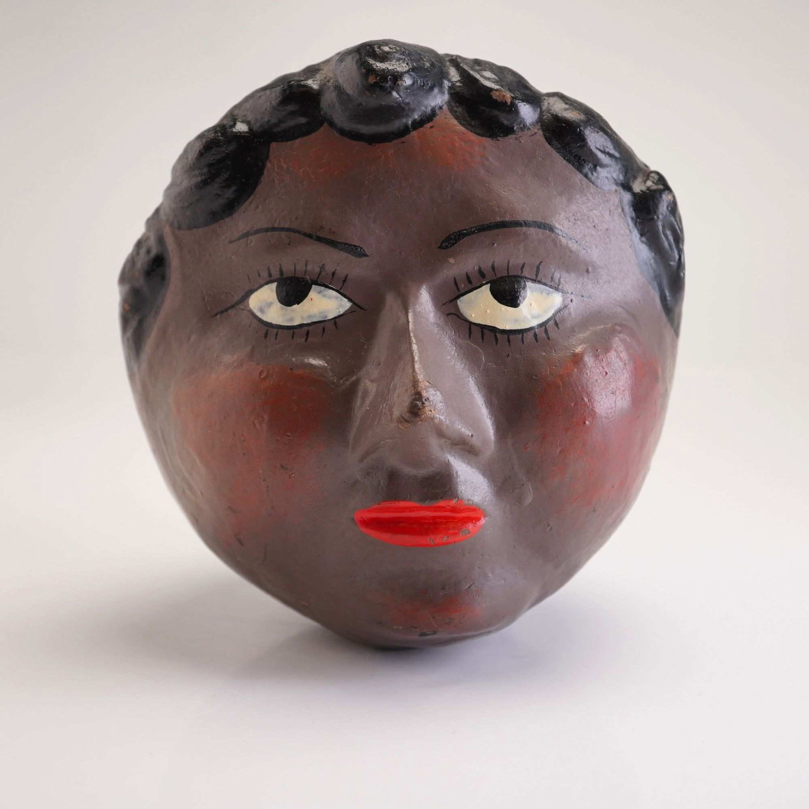 Vintage Black Americana Woman's Head Ceramic Coin Bank: A vintage hand-painted ceramic coin bank sculpted in the form of a woman's head, designed in the Black Americana folk art style. The bank is constructed of a molded pottery or clay body with a dark br