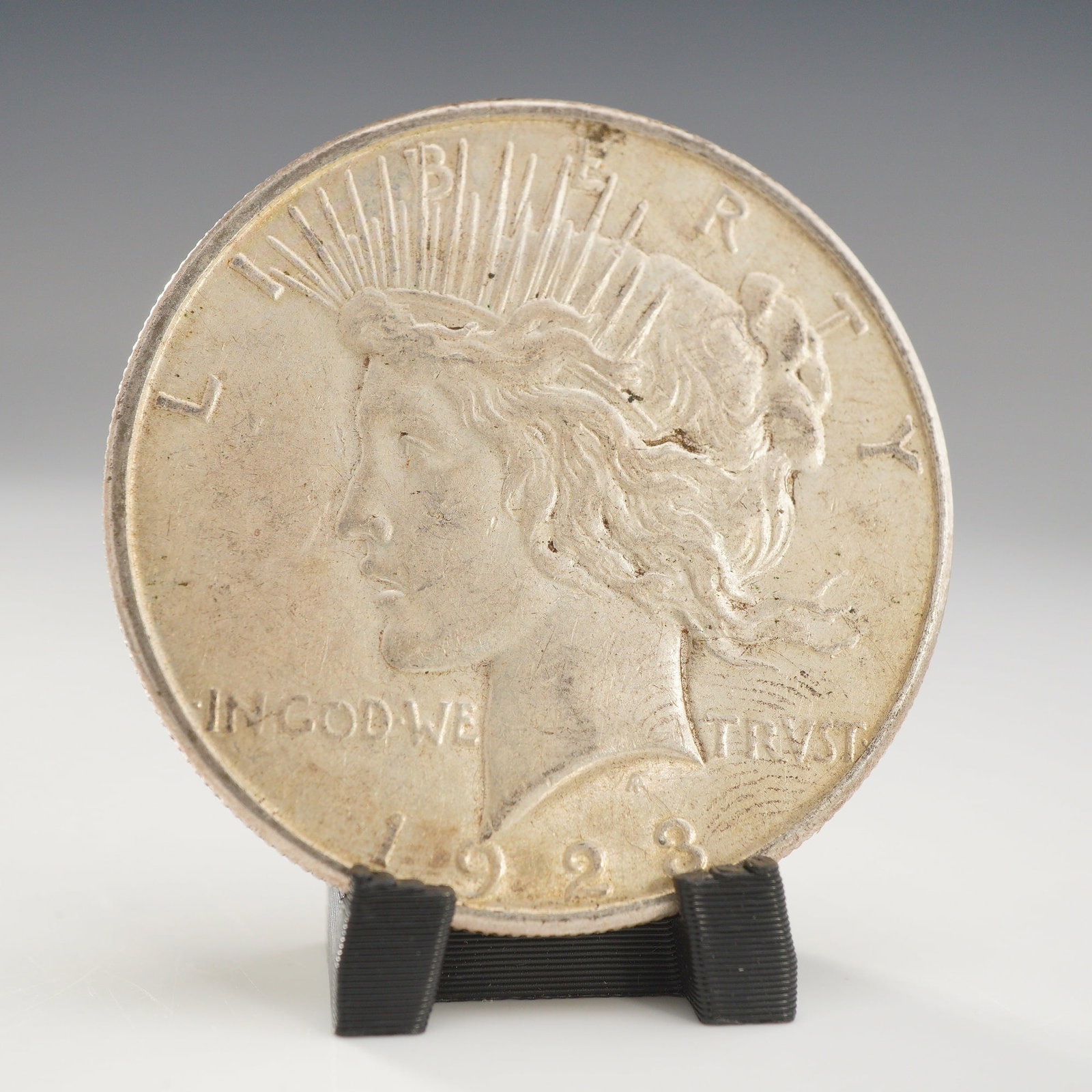 1923-S US Peace Silver One Dollar Coin, Circulated: This US 1923-S Peace silver dollar is composed of 90% silver and 10% copper. Struck at the San Francisco Mint. The coin features the standard Peace Dollar obverse and reverse designs by Anthony de Fra
