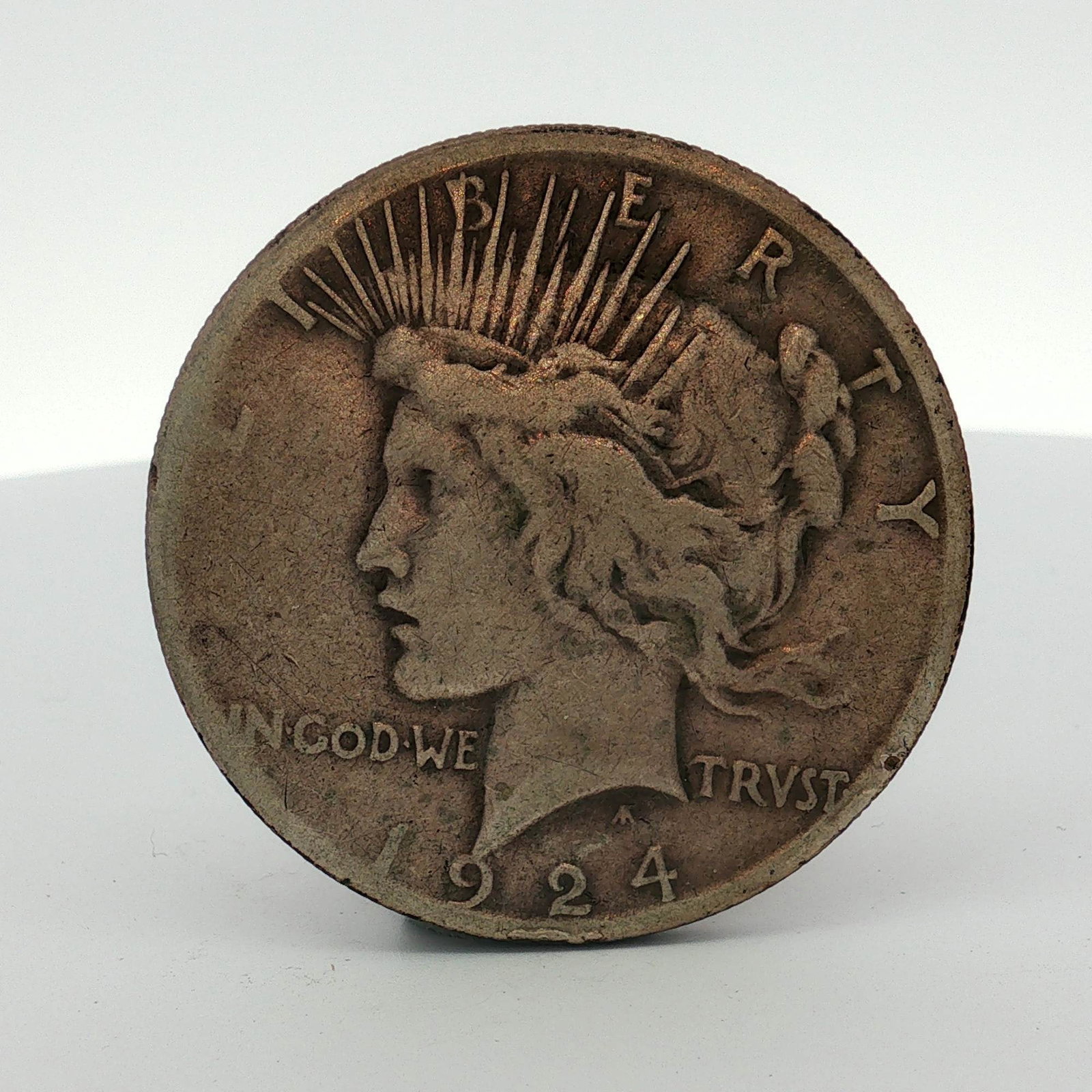 1924-S US Peace Silver Dollar: This US Peace dollar was produced at the San Francisco Mint in 1924. The coin is struck in a low relief format and composed of 90% silver. It features the Peace dollar obverse design type with the AF 