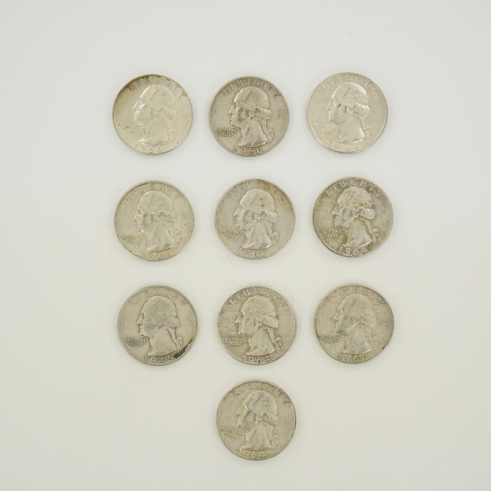 10pc Pre-1964 U.S. 90% Silver Washington Quarters: A collection of ten US Washington Quarter Dollars struck in 90% silver (.900 fineness). This mixed date bag of coinage includes one 1945, two 1961, one 1962, one 1963, and five 1964 issues. These coin