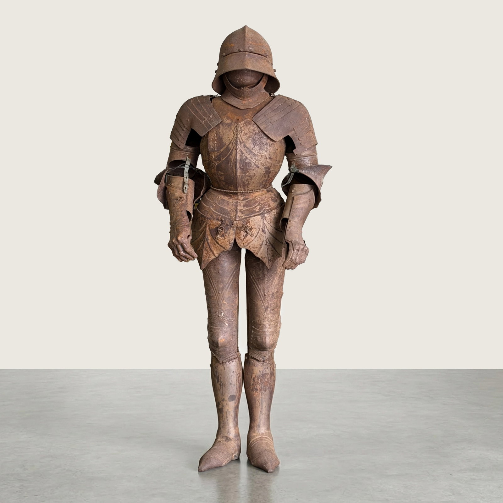 German Gothic Style Full Suit of Plate Armor: This decorative armored suit is modeled after late 15th-century German Gothic plate armor. The assembly includes a sallet helmet with a movable visor and a separate bevor for throat protection. The to