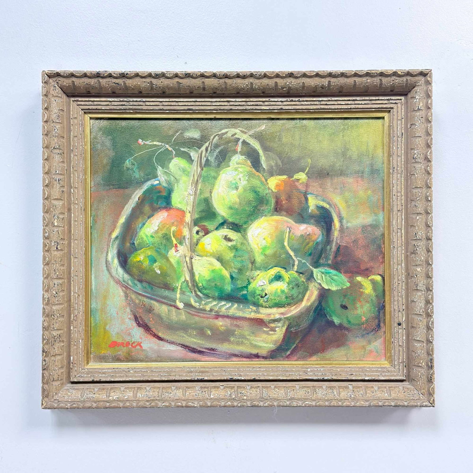 Frank Tregarthen "Brock" Brokenshaw (American, 1912??"2004), Still Life with Green Fruit in a: This mid-century still life is executed in oil on board, depicting a lush arrangement of green and yellow fruits, primarily pears, nestled within a woven basket. This painting by American artist Frank
