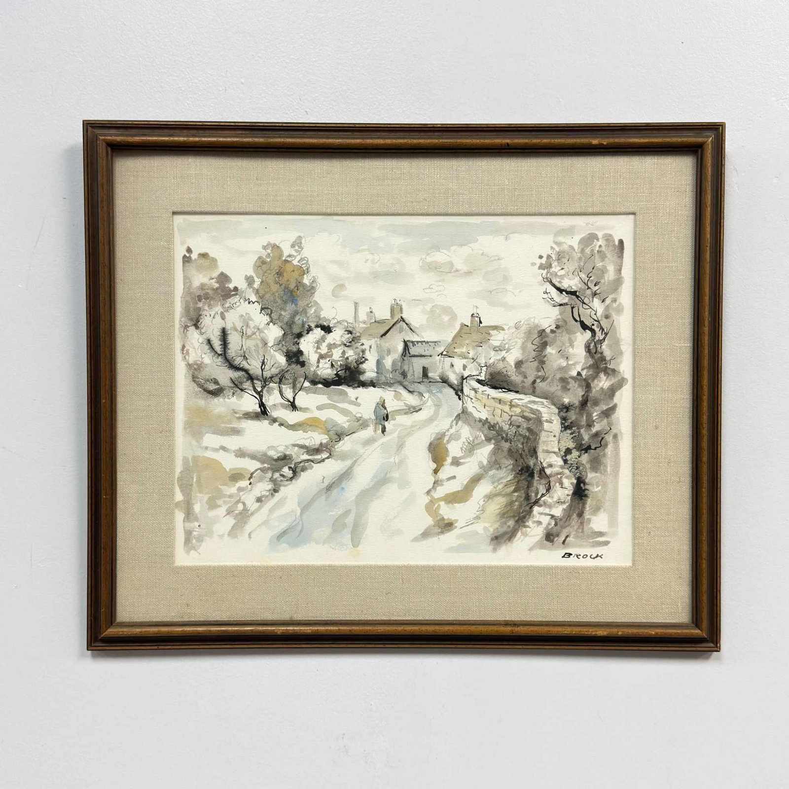 Frank Tregarthen "Brock" Brokenshaw (American, 1912-2004) Framed Village Landscape Watercolor on: This original watercolor on textured paper depicts a village landscape by American artist Frank Tregarthen Brokenshaw. The composition features a winding path leading past a low stone wall toward a cl
