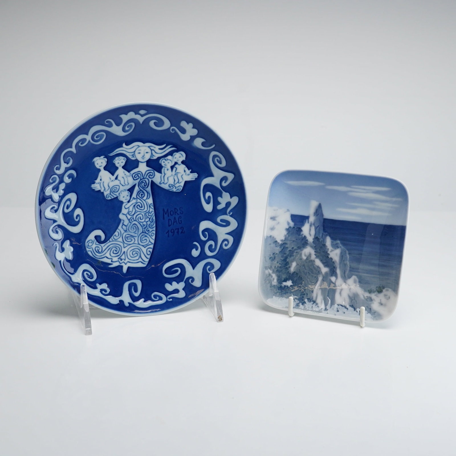 Two Royal Copenhagen Porcelain Dishes, 1972 Mother's Day Plate and Moens Klint Sommerspiret Coaster: This lot consists of two pieces of underglaze blue porcelain from Royal Copenhagen, Denmark. The first item is a circular commemorative wall plate from 1972. The front features a stylized central figu