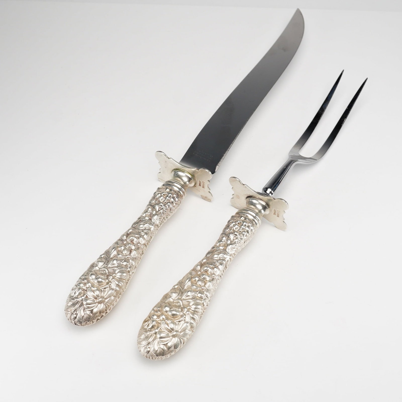 2pc Kirk Stieff Sterling Silver and Stainless Steel Fork and Knife Carving Set, Stieff Rose: A two-piece carving set in the celebrated "Stieff Rose" pattern by Kirk Stieff, introduced in 1892. This set includes a carving knife and serving fork, each featuring ornate sterling silver handles wi