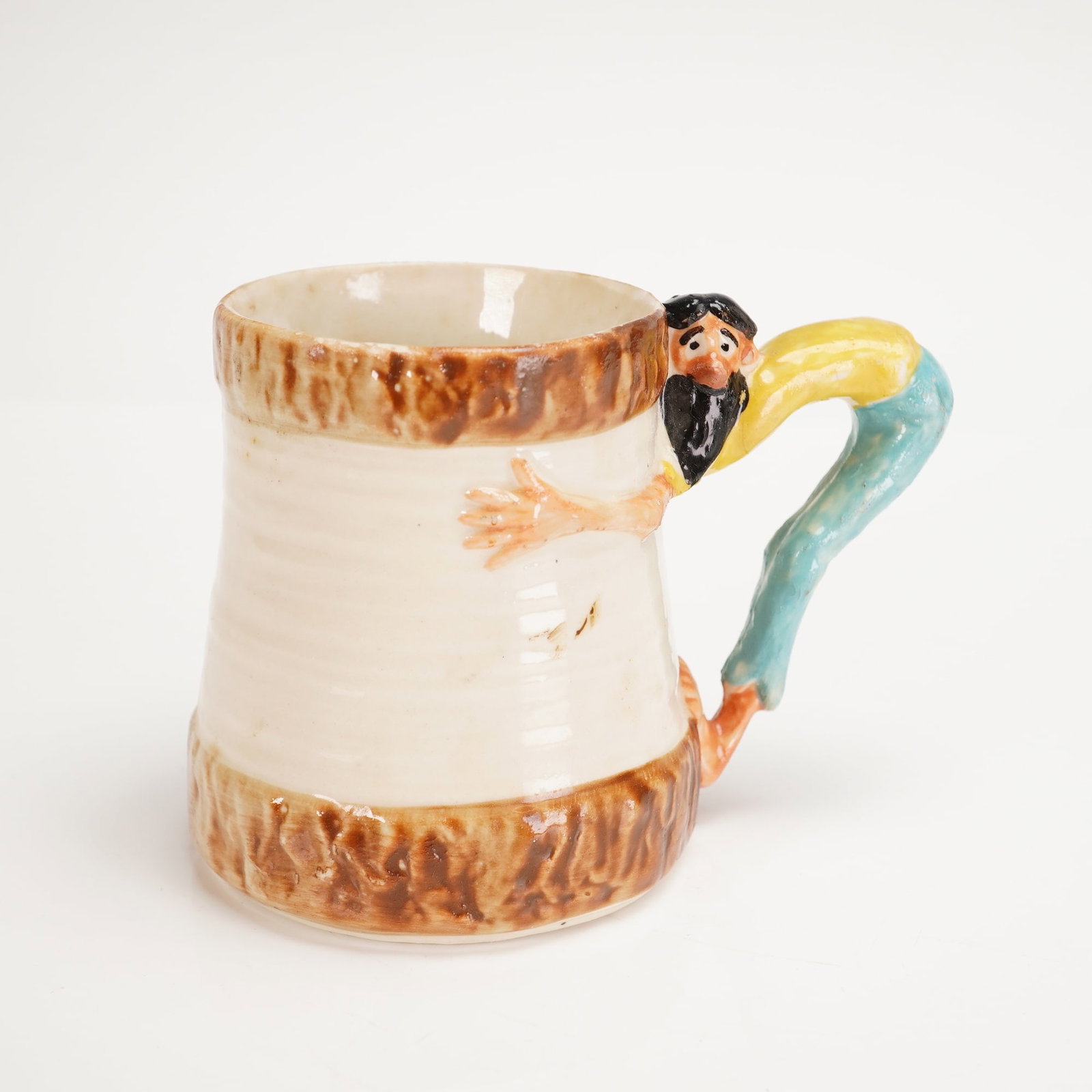 Imperial Porcelain Paul Webb Mountain Boys Hillbilly Mug: A single ceramic mug, attributed to designer Paul Webb for Imperial Porcelain Corp., Zanesville, Ohio, circa 1948, part of the 'Mountain Boys' or 'Hillbilly' series. The cylindrical body tapers slight