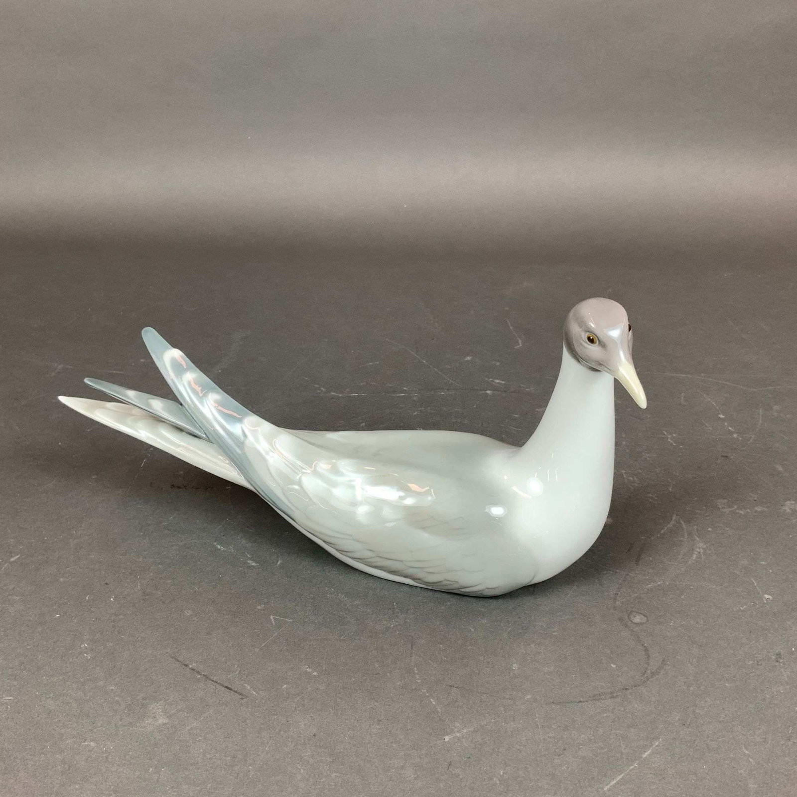 Lladro Porcelain Figurine, Tern 01001051: This Lladro glazed porcelain figurine, model number 01001051 and titled Tern, depicts a sea bird in a resting pose. The piece is finished in a high-gloss glaze with a soft-toned color palette, featuri