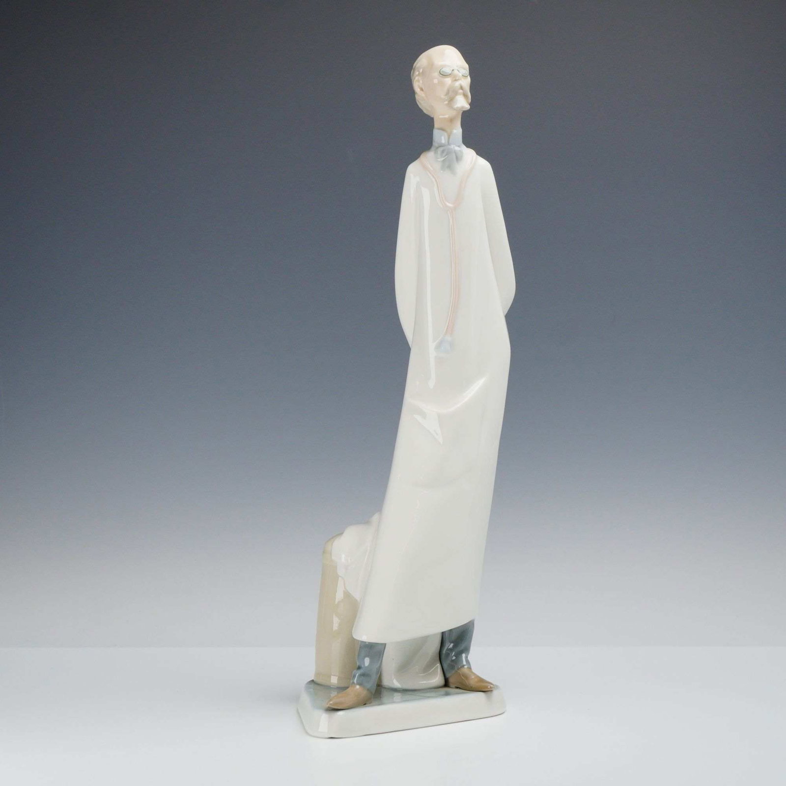 Lladro Glazed Porcelain Figurine, The Doctor 4602: A Lladro glazed porcelain figurine titled The Doctor (Medico), model number 4602, designed by sculptor Salvador Furio and issued in 1968. The piece features an elderly physician in a characteristic el