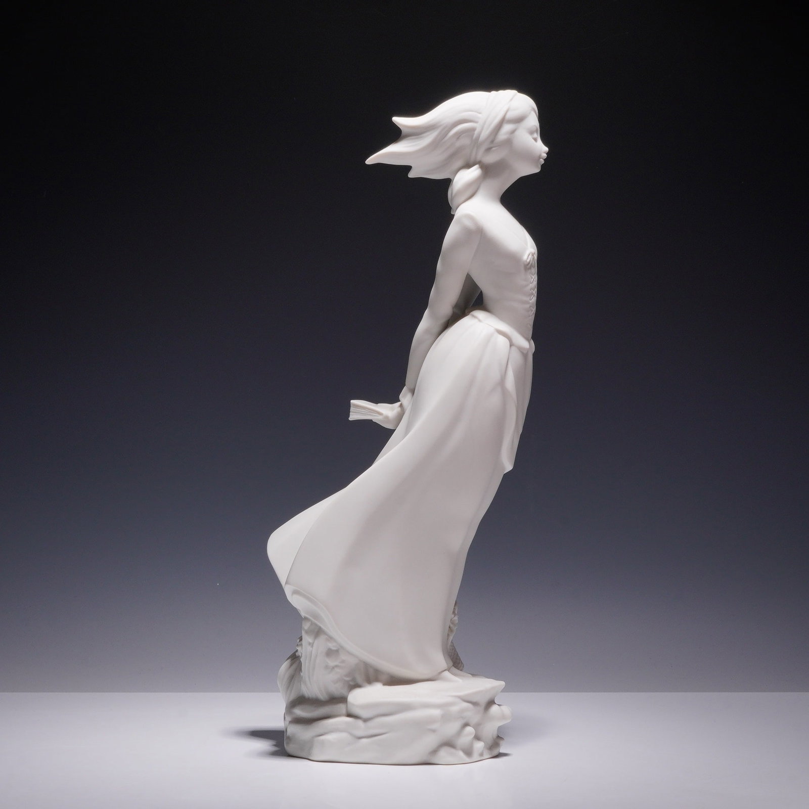 Lladro Porcelain White Figurine, Wind Blown Girl 01014922.3: This unpainted Lladro bisque porcelain sculpture is titled Sea Breeze, also known as Wind Blown Girl, model number 4922. The figurine depicts a young woman in a flowing dress leaning forward as if sta