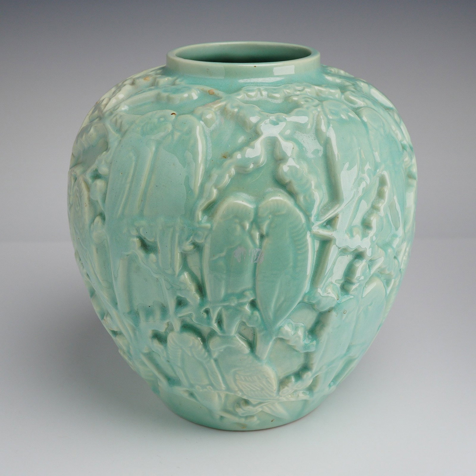 Stangl Pottery Turquoise Love Birds Table Planter: A decorative ceramic globular jar featuring an all-over pale turquoise or celadon green glaze. The vessel is constructed with high-relief molded decoration depicting various birds perched among