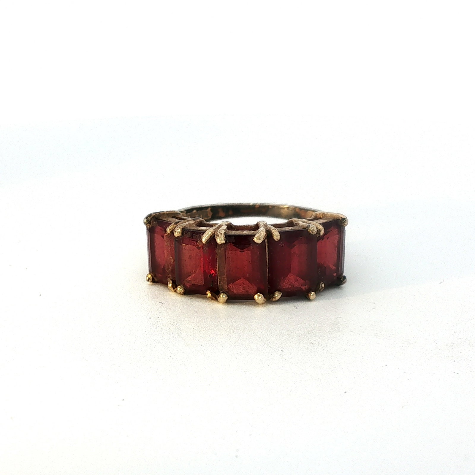 10K Gold Emerald Cut Red Gemstone Ring: Crafted from 10K gold, this ring features five emerald-cut red gemstones. Stamped 10k. Thermo Scientific Niton XL2 XRF Precious Metal Analyzer tested. Dimensions: Ring size 6.5 Weight: 3.20g