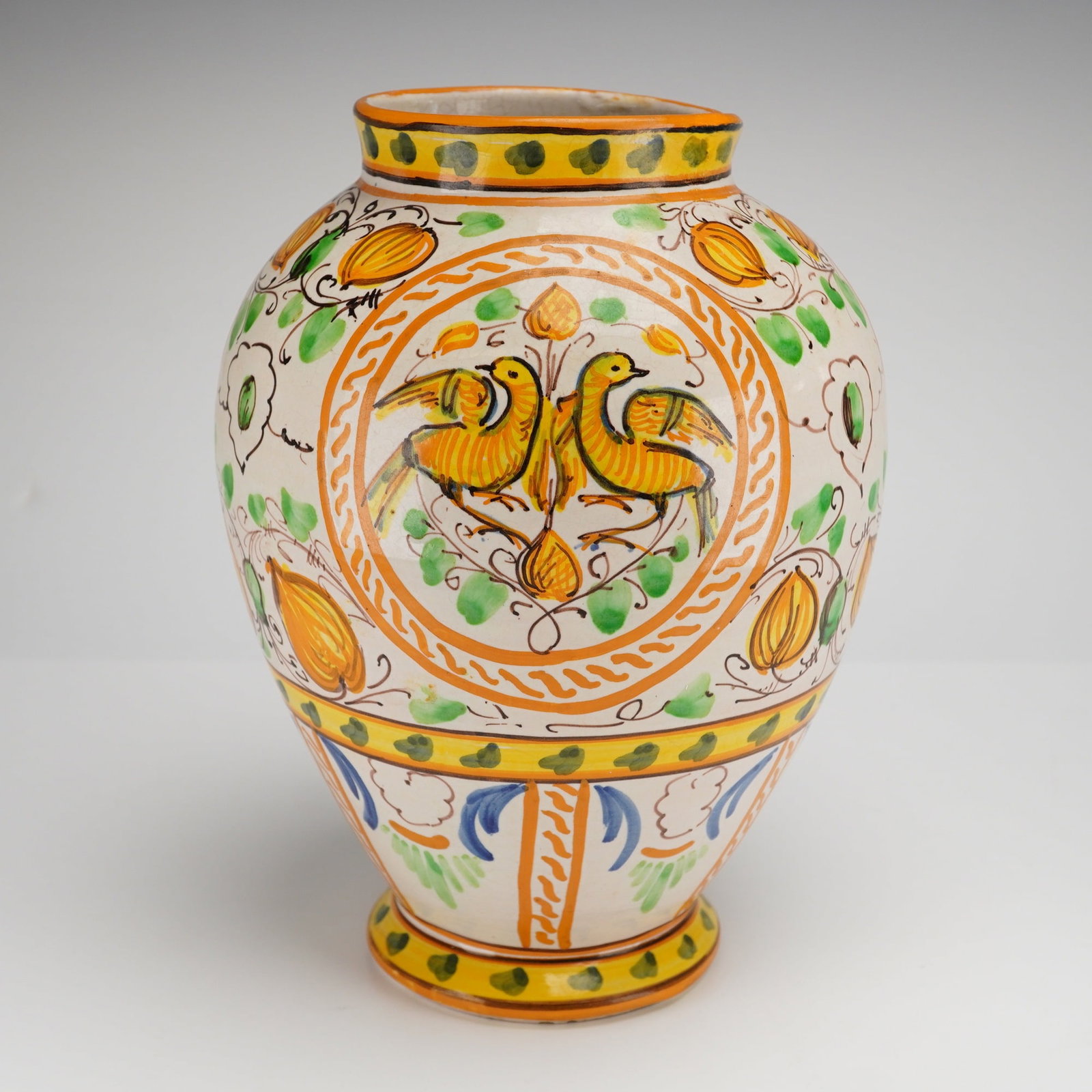 Italian Deruta Majolica Hand Painted Ceramic Vase: This mid-20th-century Italian hand painted vase is produced in the Deruta majolica style. The ceramic vessel features an ovoid body with a short neck and a flared foot. The exterior decoration consist