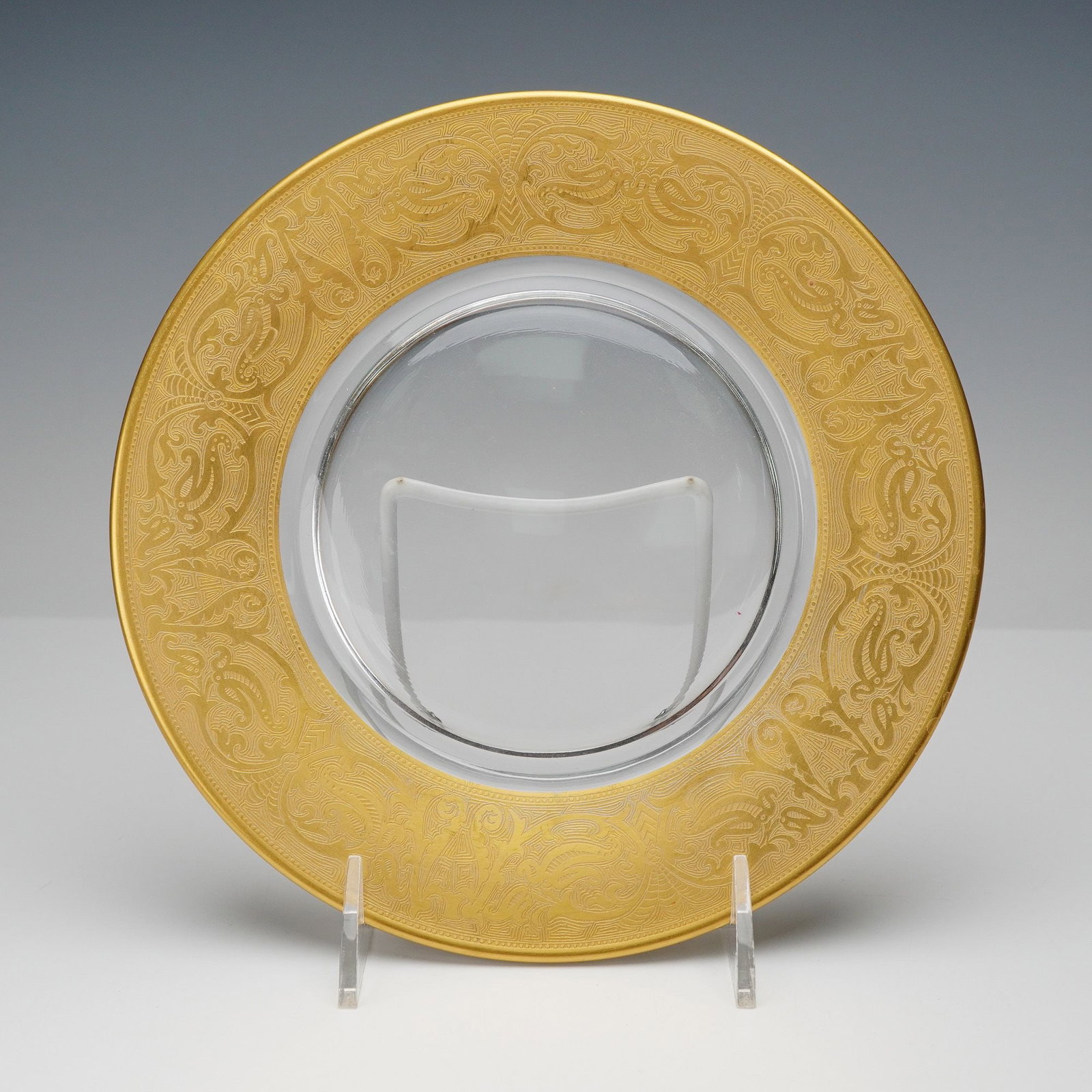Georgian Gold Rimmed Decorative Plate: An elegant decorative plate showcasing a luxurious wide gold rim with intricate neoclassical motifs finely etched in relief, framing a clear glass center. The detailed design features ornate scrollwor